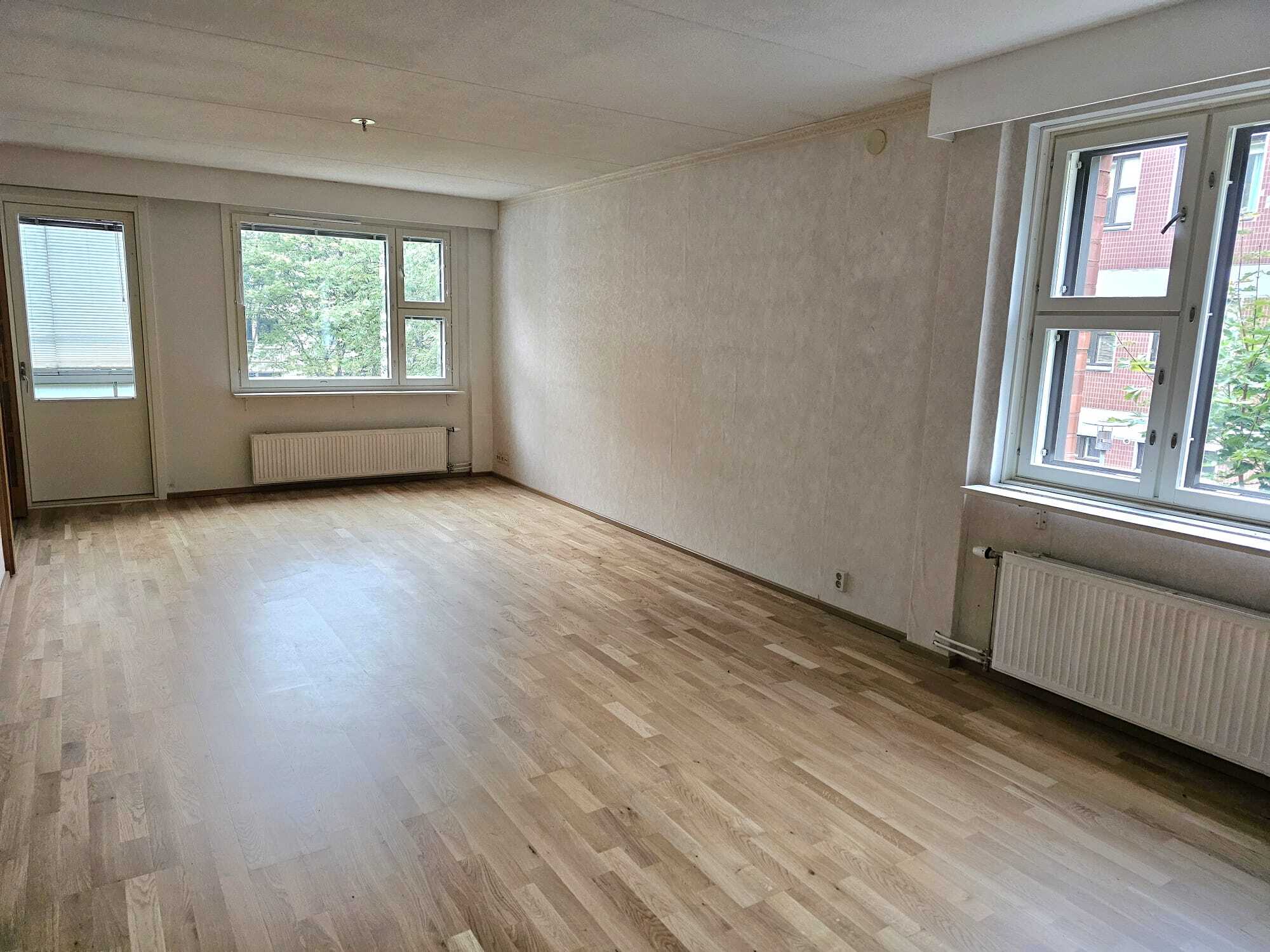 Olohuone uusilla ikkunoilla ja parvekkeen ovella