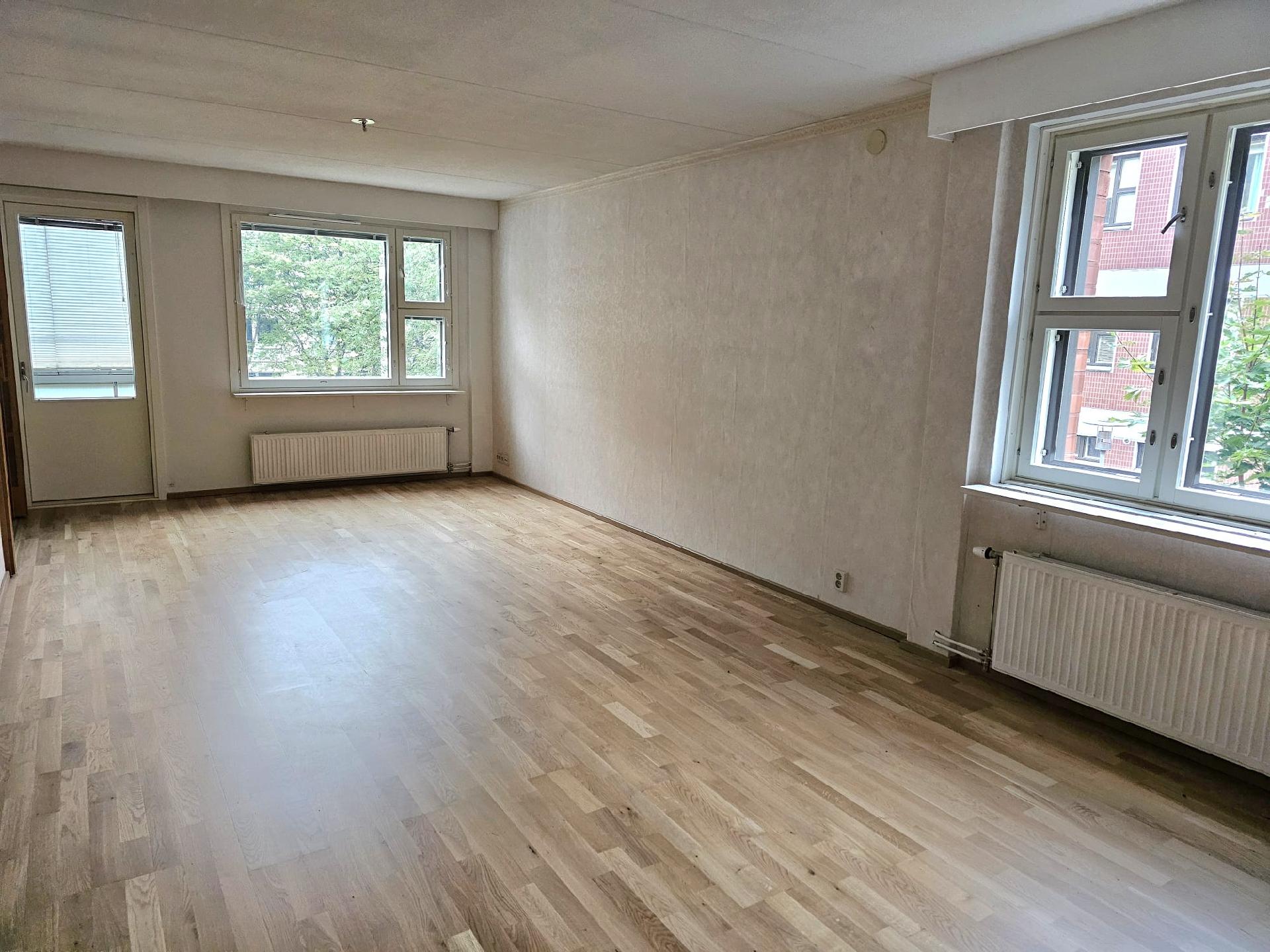 Olohuone uusilla ikkunoilla ja parvekkeen ovella