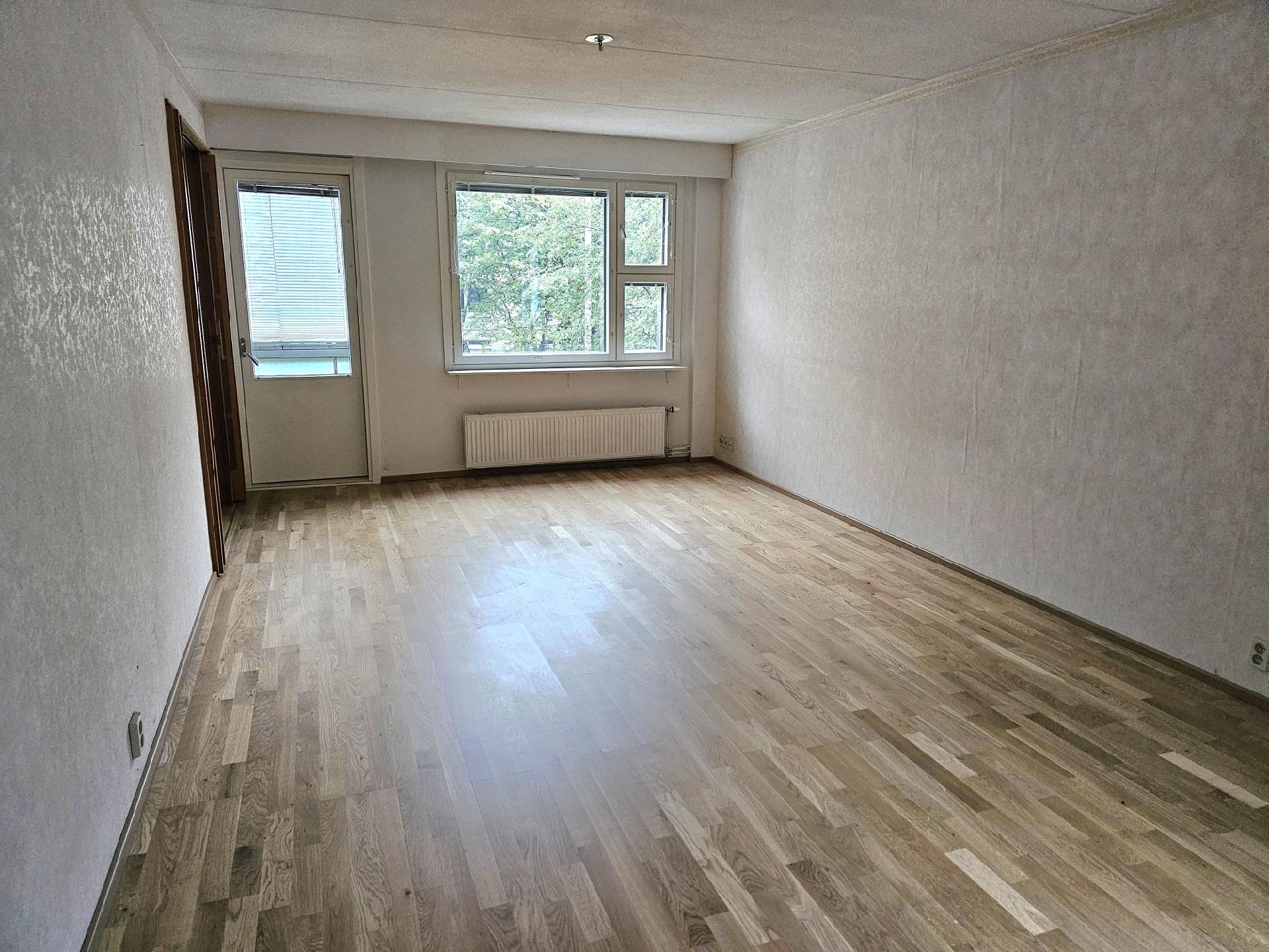 Olohuone uusilla ikkunoilla ja parvekkeen ovella