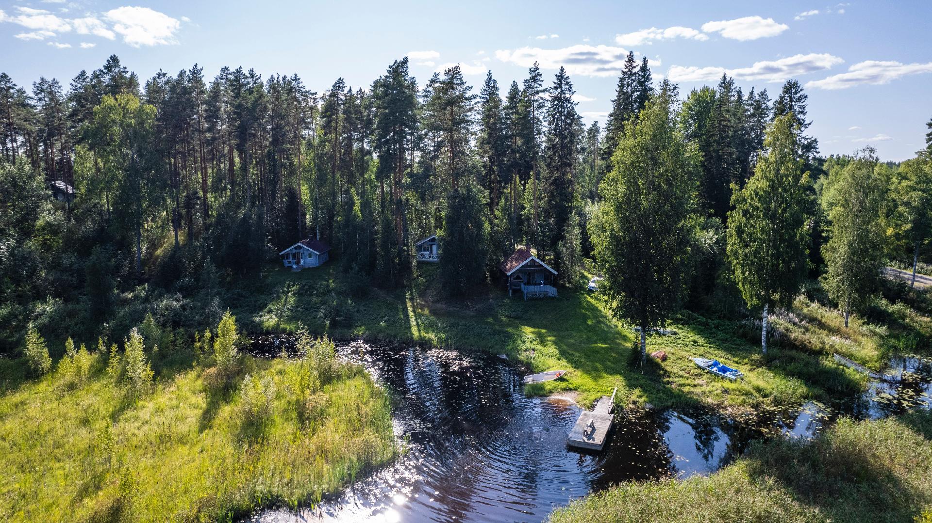 Rannassa kolme erillistä mökkiä