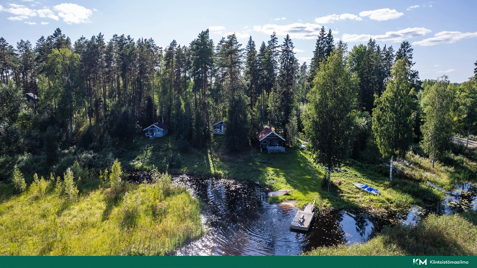 Rannassa kolme erillistä mökkiä