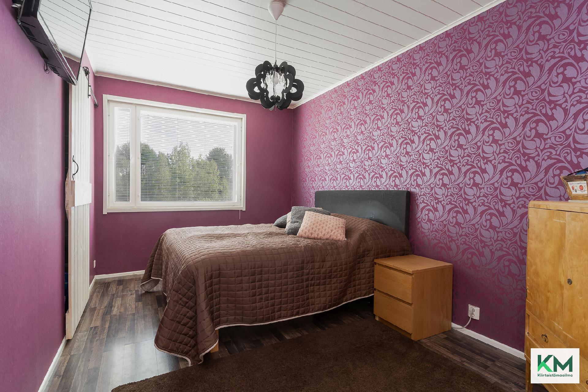 Isomman asunnon makuuhuone.