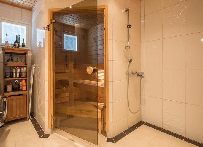 Löylyhuone on sijoitettu tilaa säästävästi. Suihkutila oikealla.