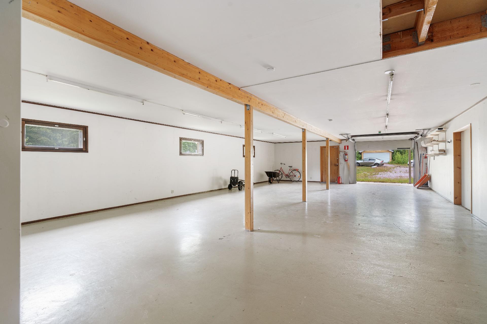 Tulokerroksessa iso autotalli nosto-ovella.