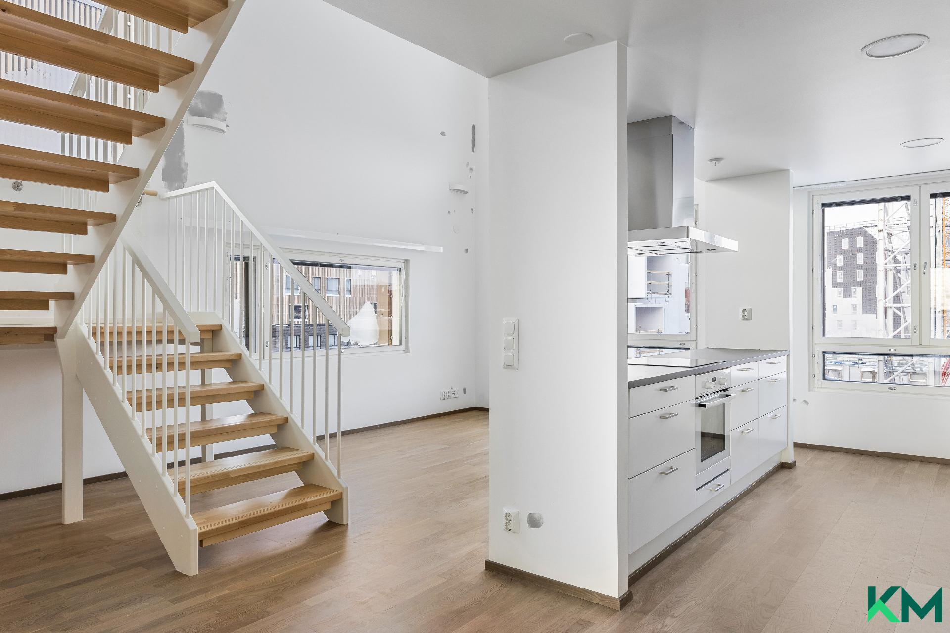 Keittiö saumattomasti yhteydessä korkeaan ruokailutilaan