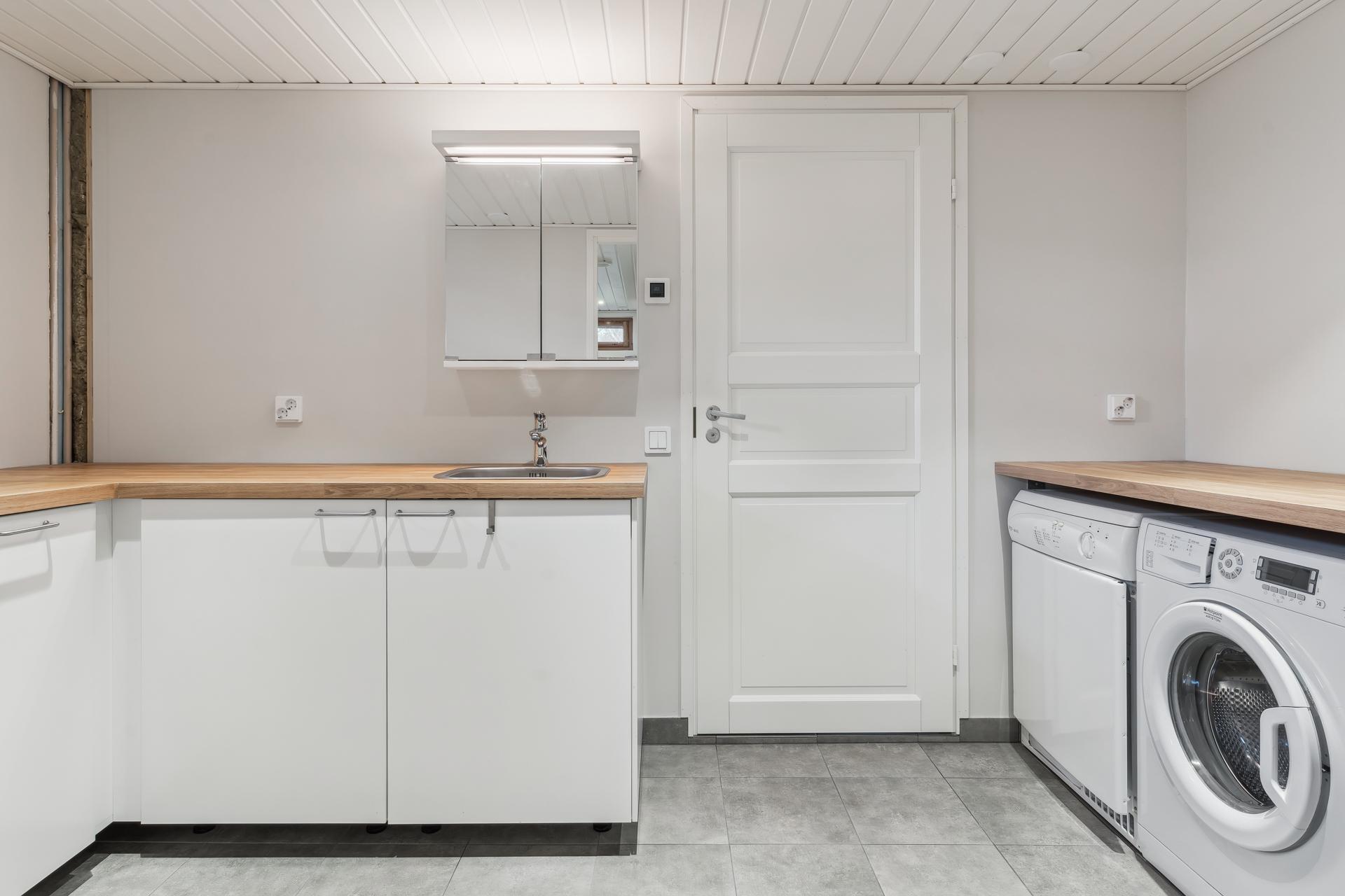 Kodinhoitohuone, josta käynti autotalliin