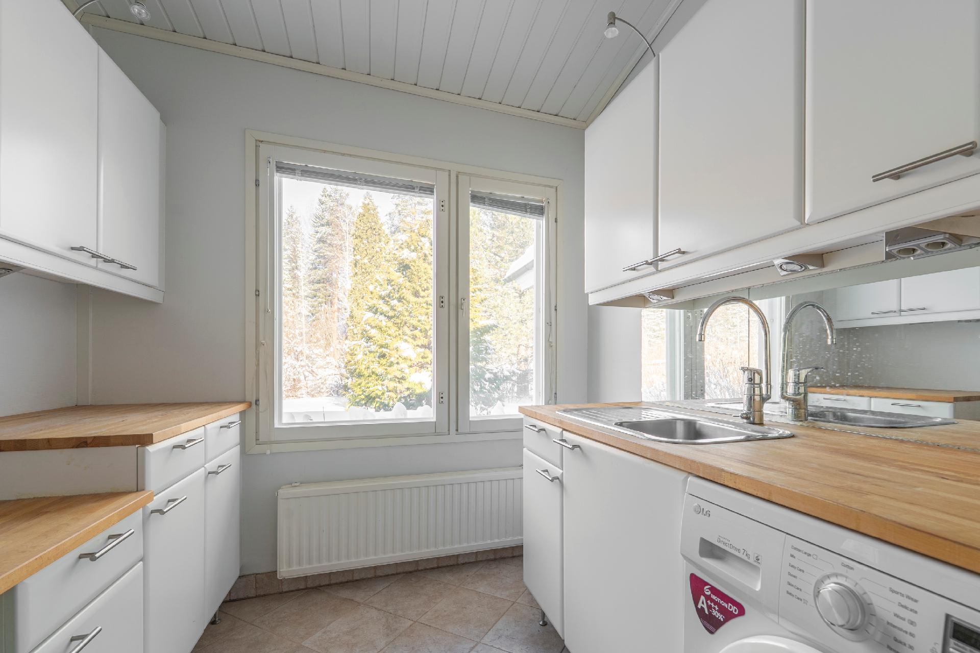 Käytännöllinen kodinhoitohuone keittiön takana