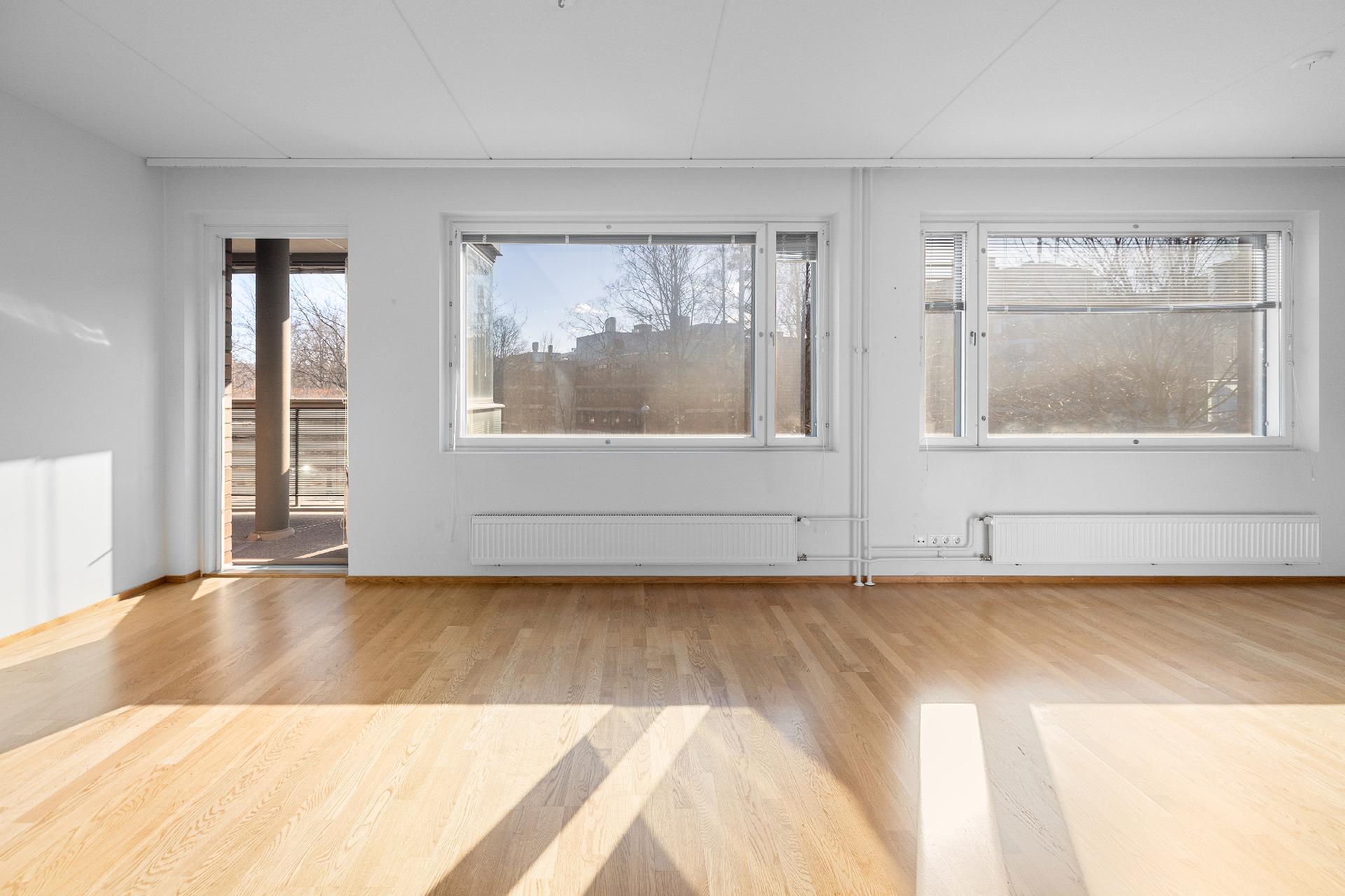 Olohuoneesta käynti isolle lasitetulle parvekkeelle.