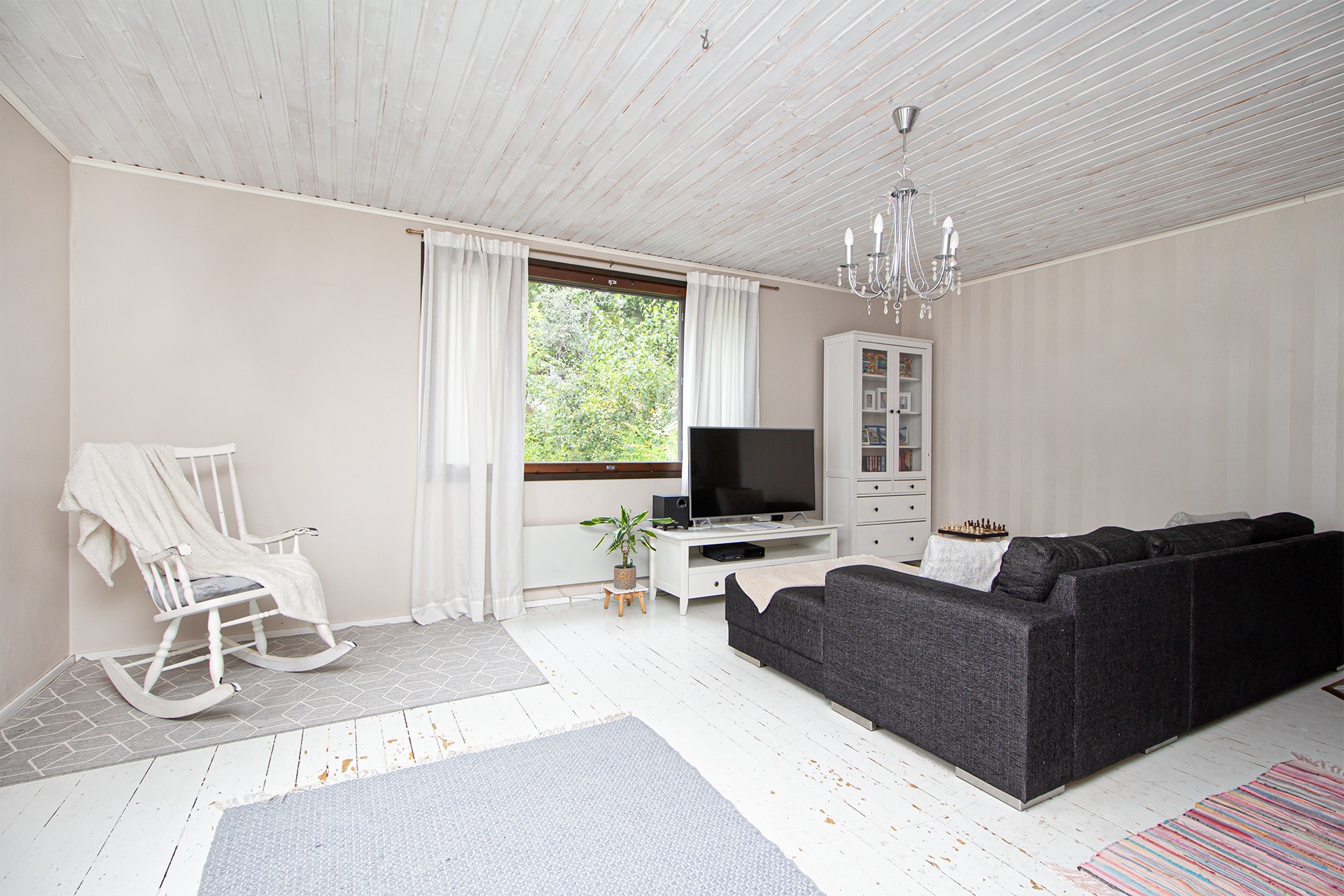 Olohuoneessa puulattiat ja näkymät takapihalle.