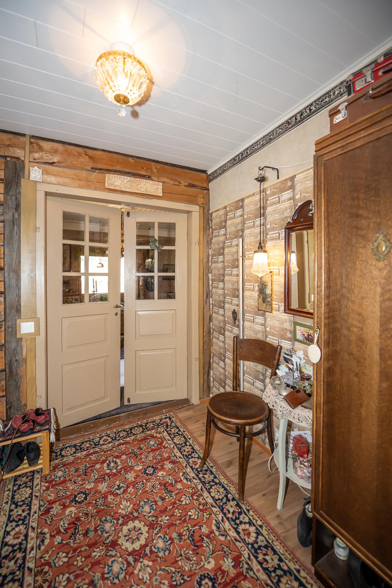 Eteisessä säilytystilaa tuolin takana olevassa komerossa.