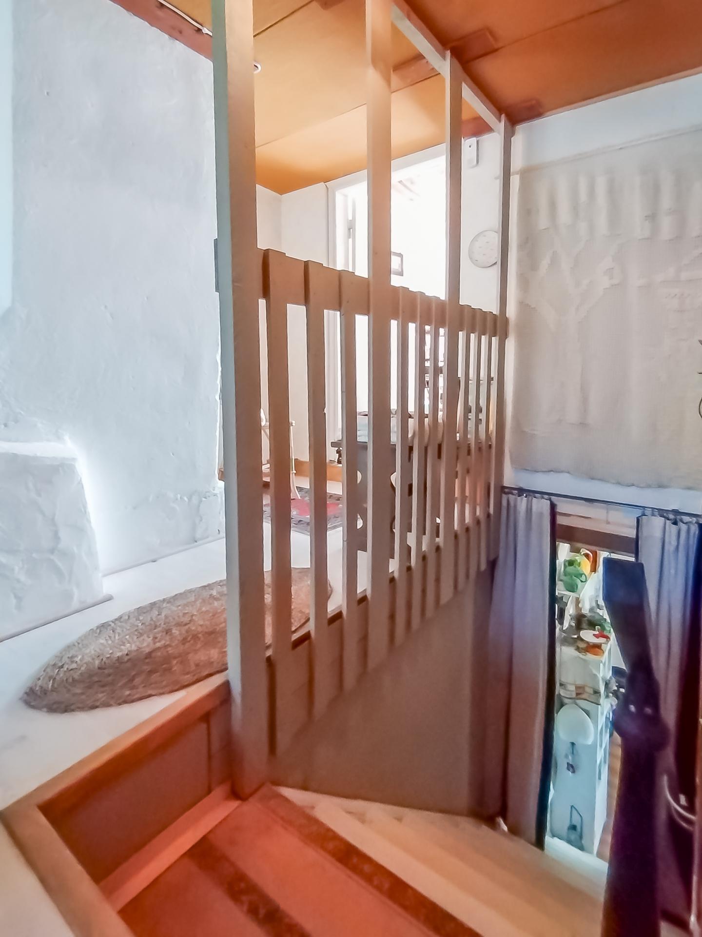 Portaat alakertaan, taustalla keittiö. 