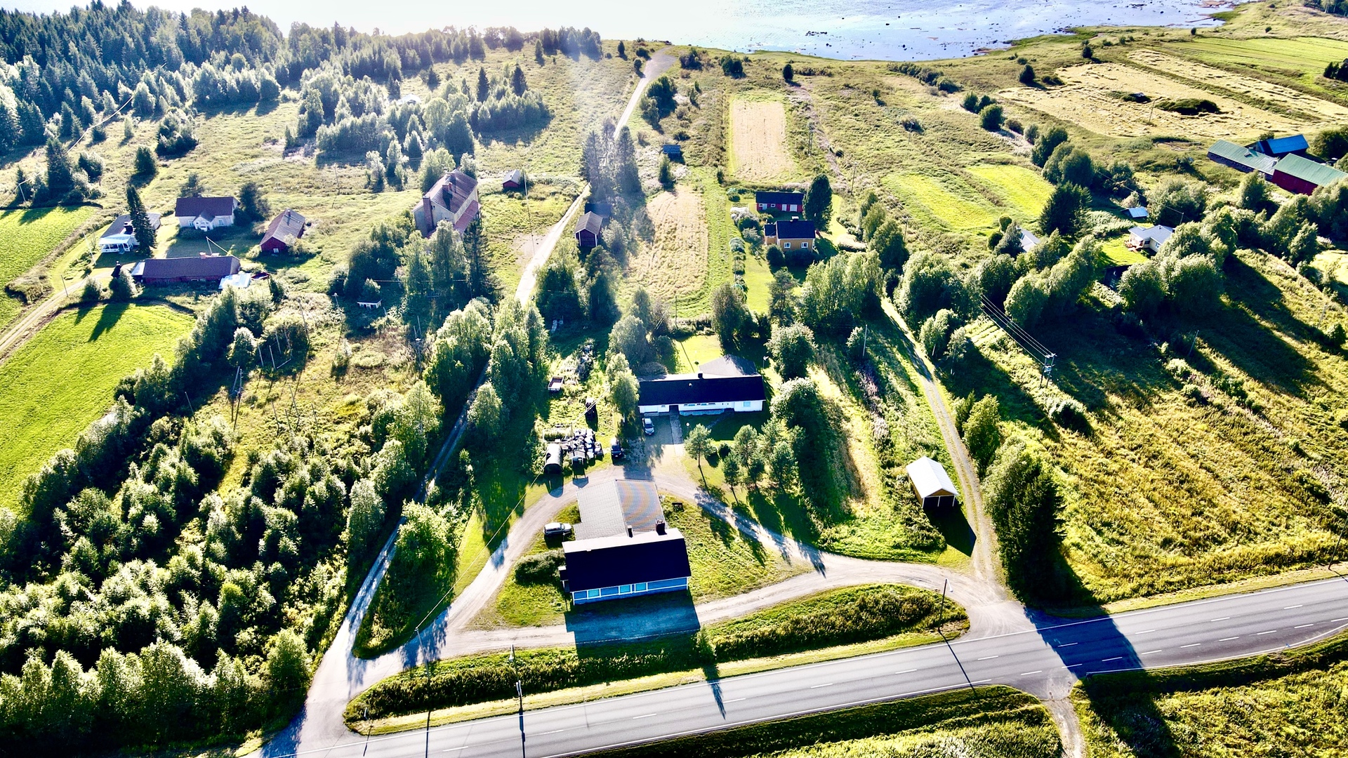 Ilmakuva kesällä määräalasta rakennuksineen (omakotitalo ja vanha kaupparakennus, jossa asuntoja)