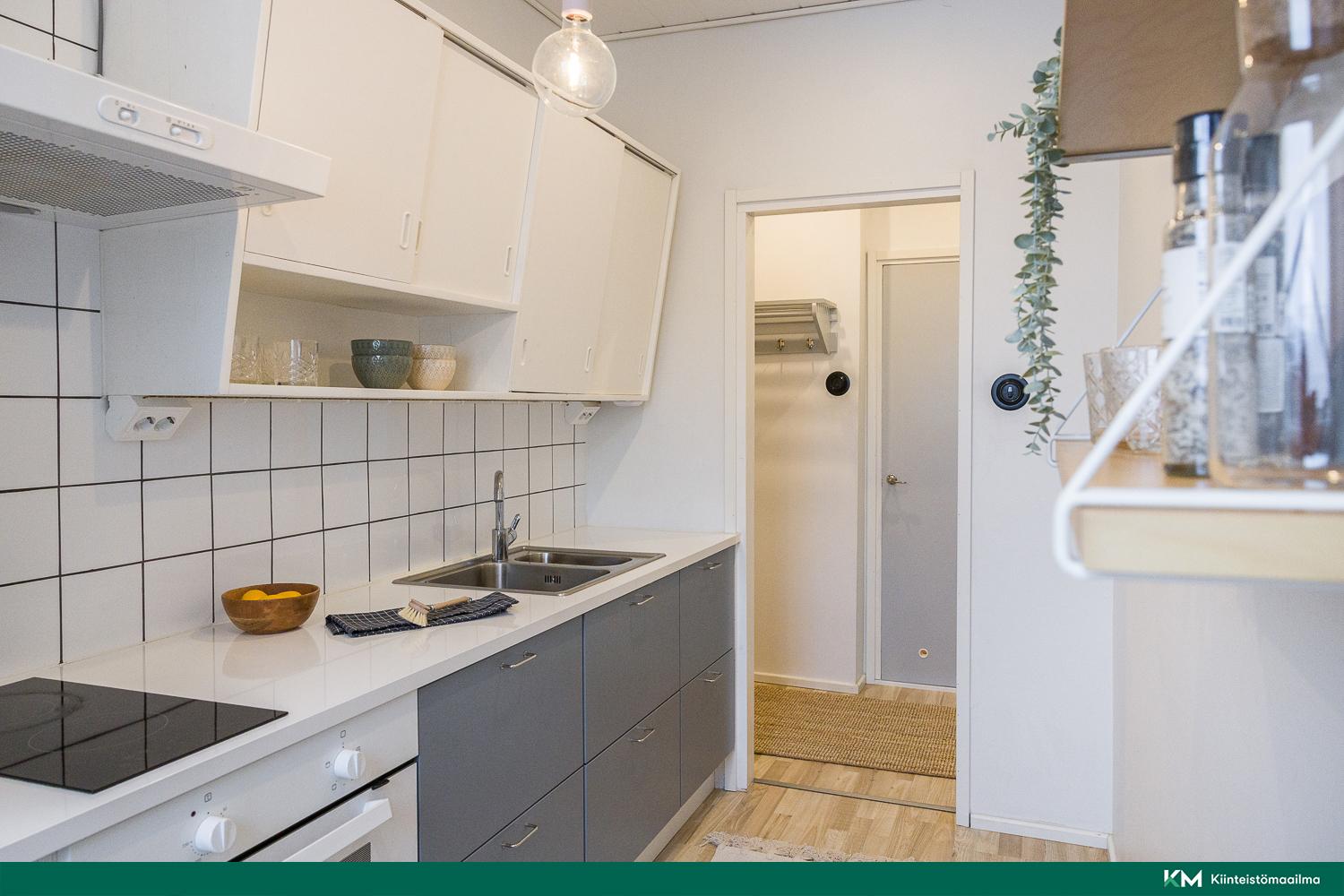 1950-luvun kunnostettu keittiönkaappi istuu tyylikkääseen keittiöön