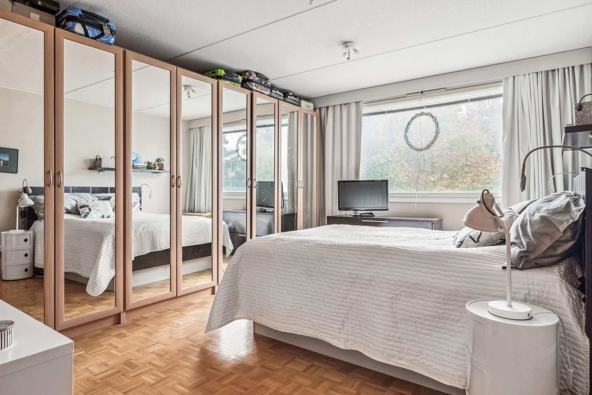 Isossa makuuhuoneessa koko seinän täytteinen vaatekaapisto