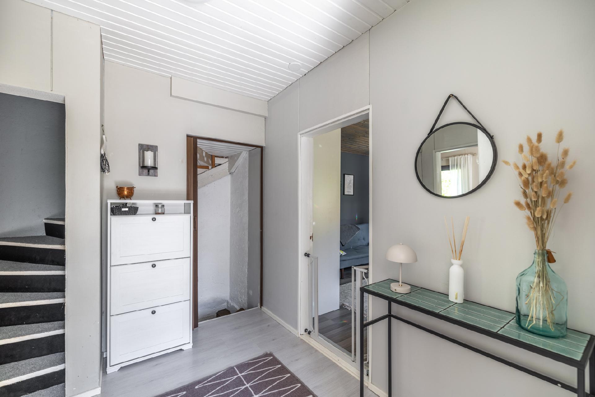 Eteisestä lähtee raput kellariin sekä yläkertaan, oikealla toinen makuuhuone