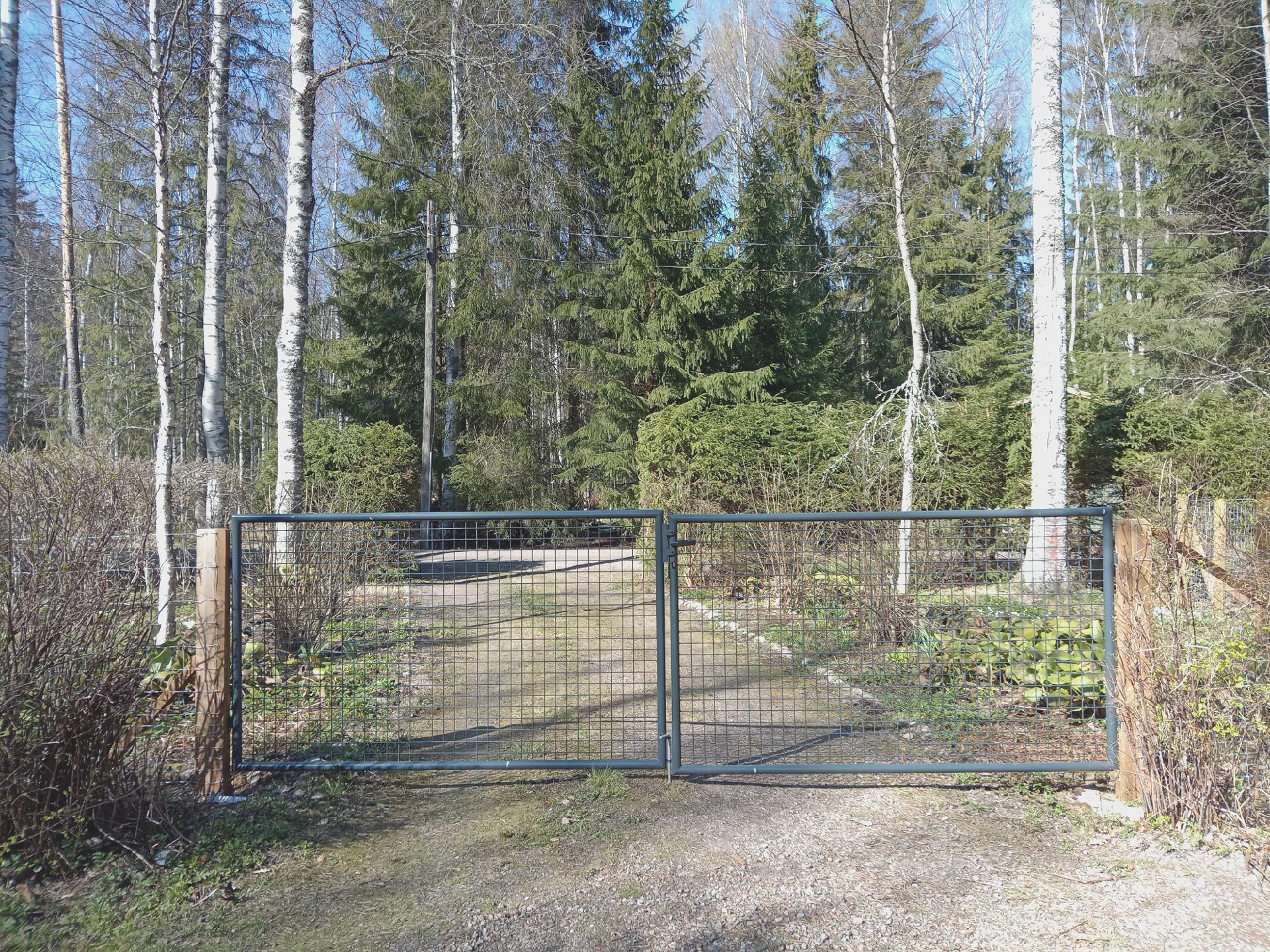 Mökkiportti. Piha on aidattu myös rannan puolelta