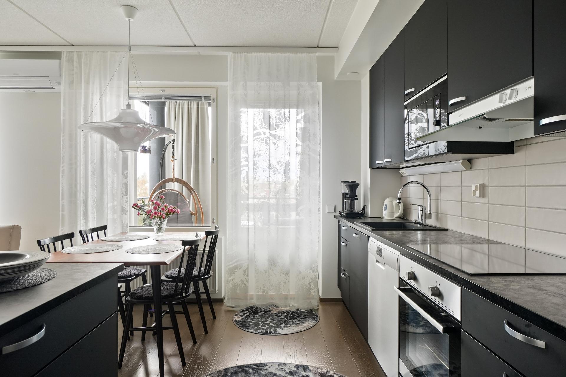 ... ja vastapainona tumma keittiö tuo tilaan särmää.