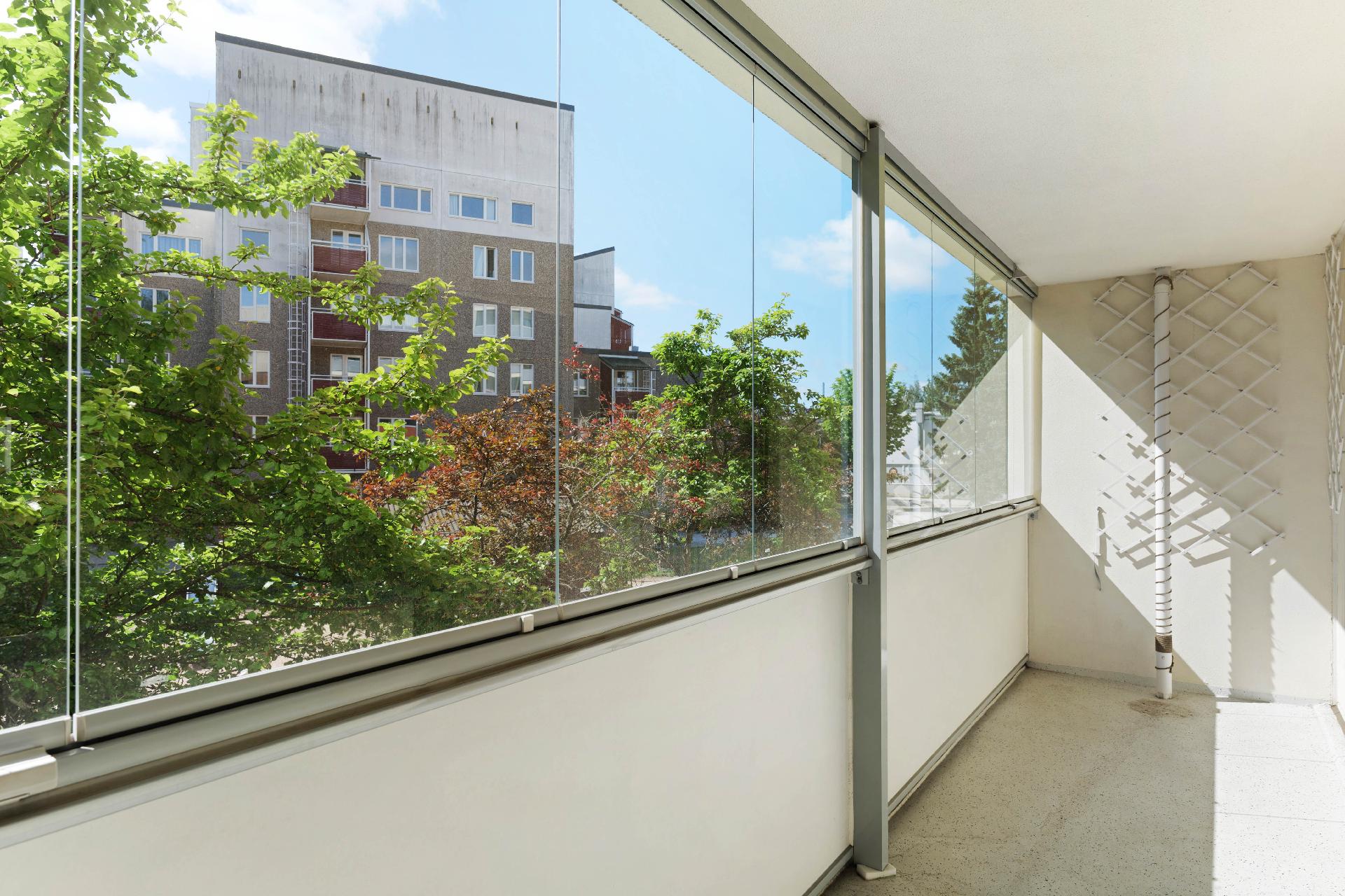 Lasitettu parveke omenapuiden siimeksessä