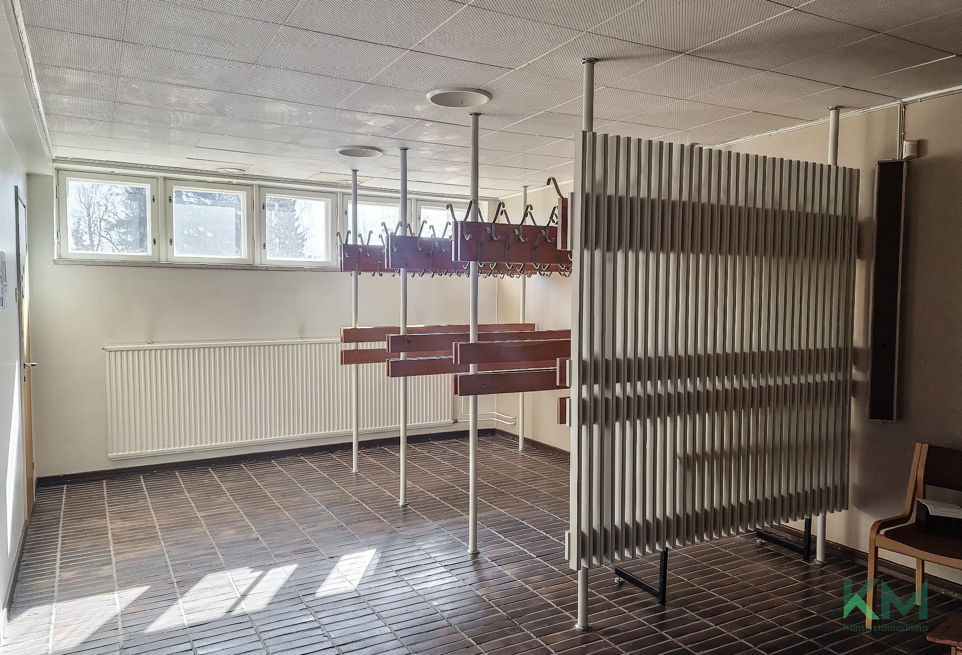 Yleisö naulakot eteisessä