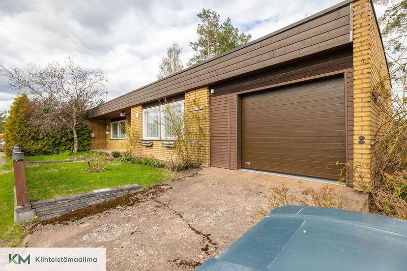 Talon päädyssä autotalli nosto-ovella