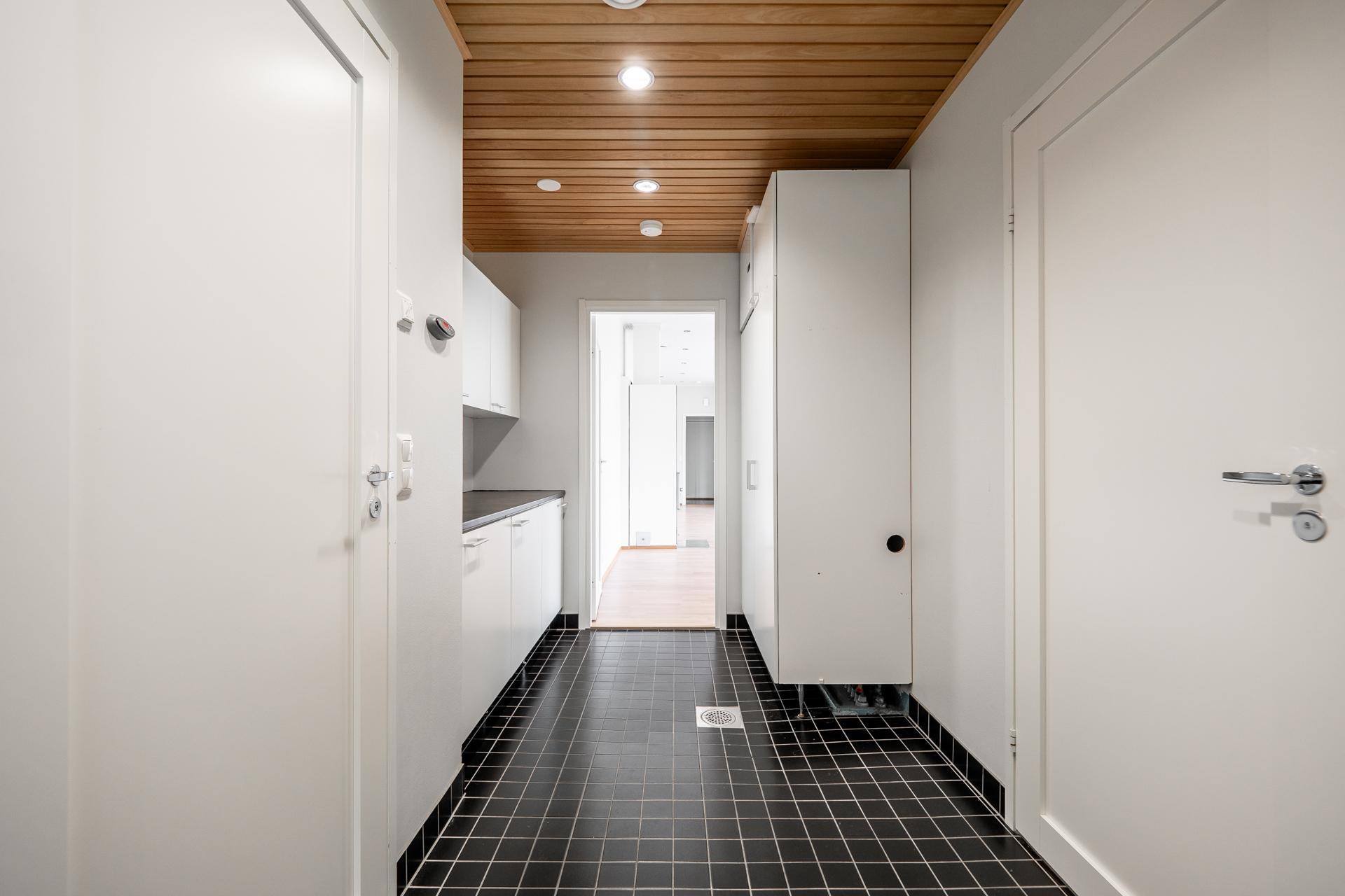 Paljon kaapistoja kodinhoitohuoneessa