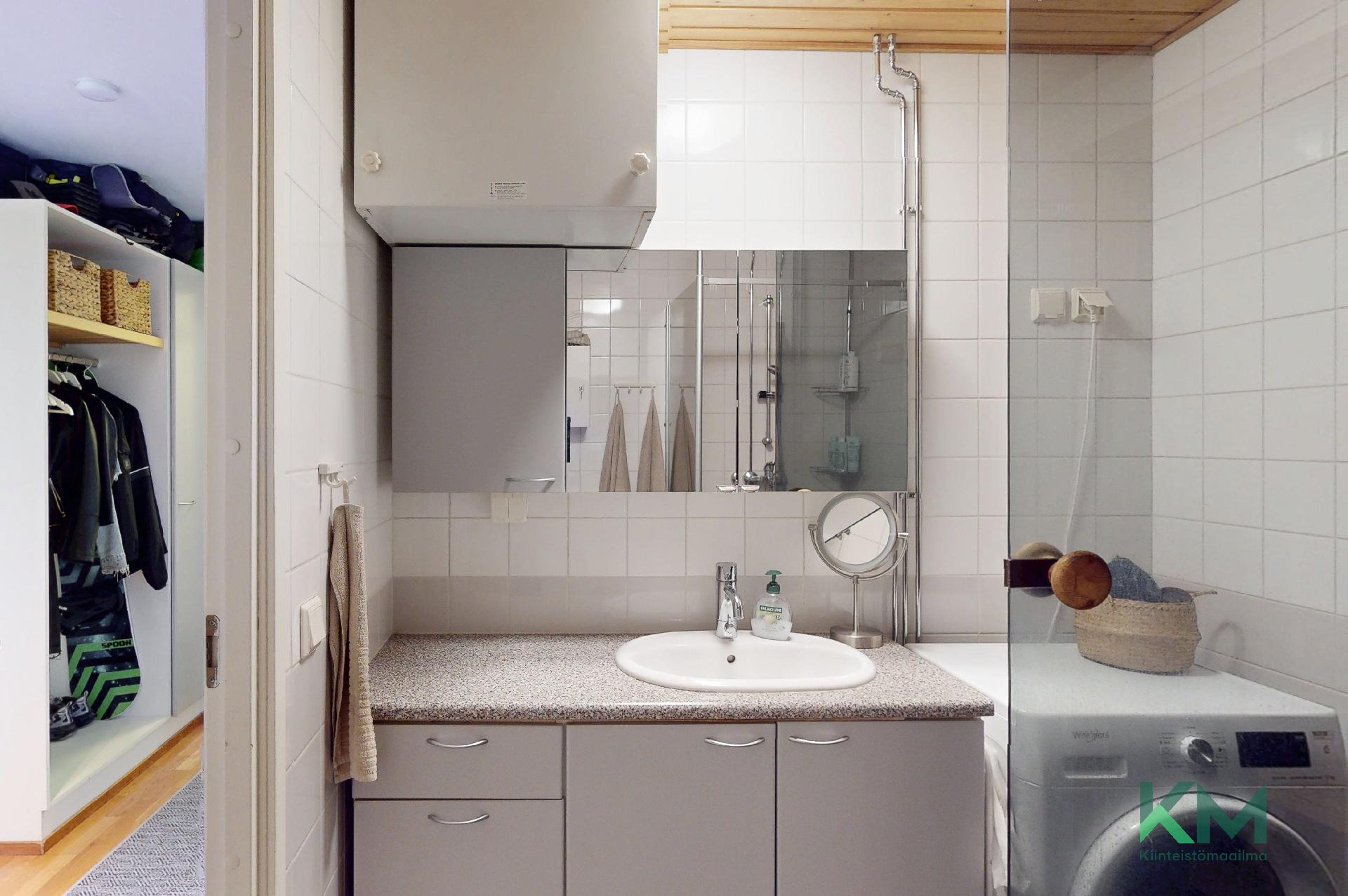 Pesuhuoneessa kiinteät kaapistot.
