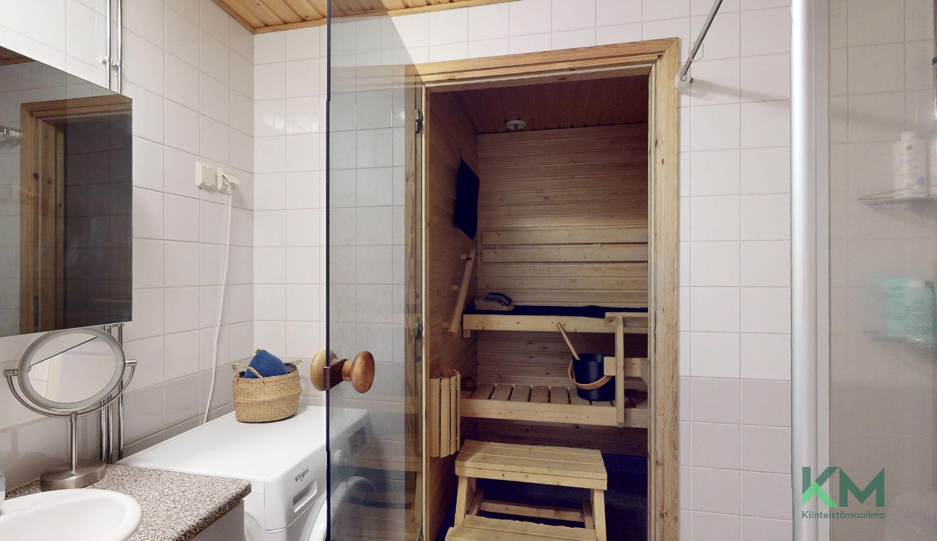 Pesuhuoneessa pesukoneliitäntä ja vessanpönttö.