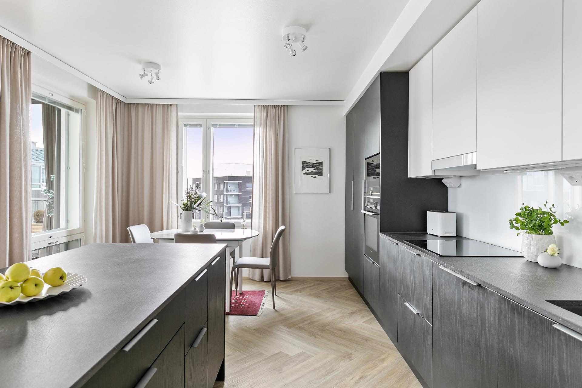 Keittiössä laadukkaat kodinkoneet ja paljon tilaa.