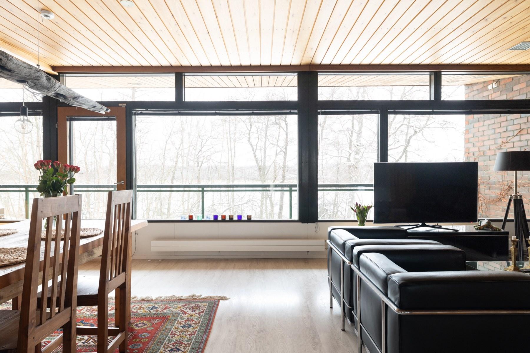 Isot ikkunat tuovat valoa olohuoneeseen ja ruokailutilaan