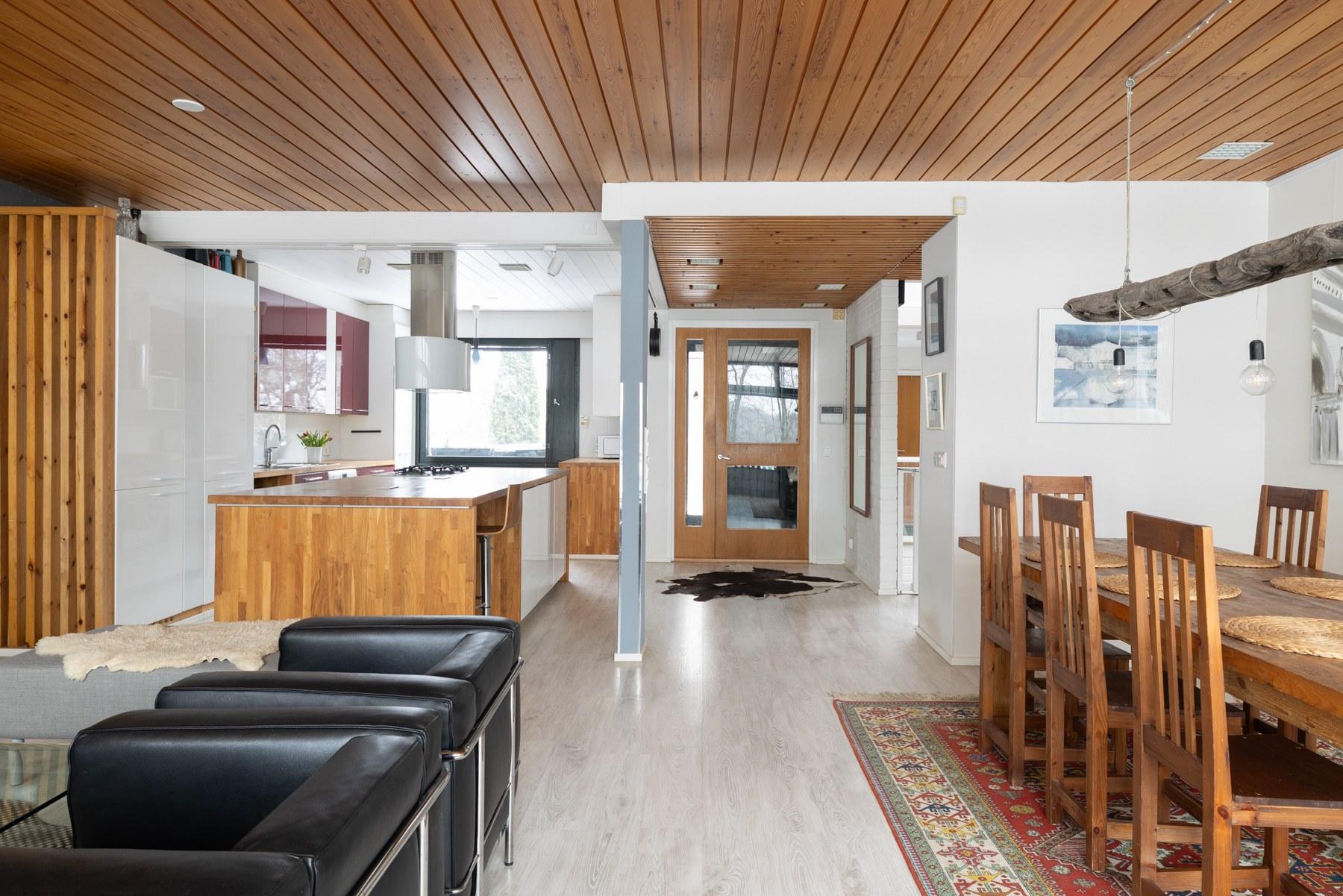 Näkymä olohuoneesta avokeittiöön ja ulko-ovelle päin