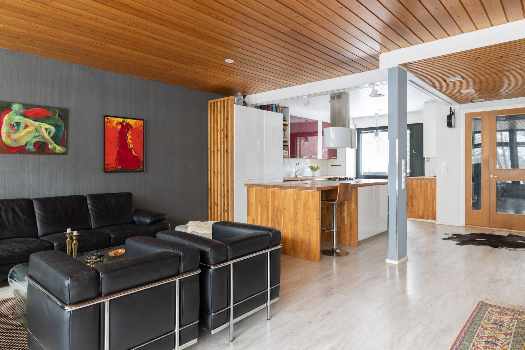 Näkymä olohuoneesta avokeittiöön ja ulko-ovelle päin