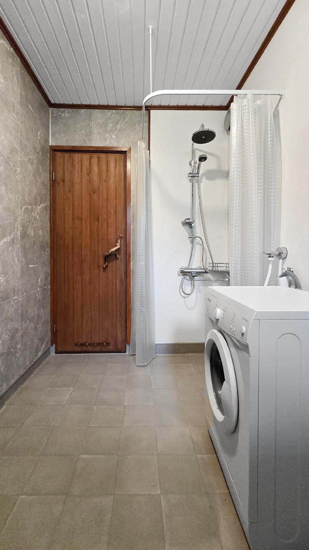 Kylpyhuoneessa valmiina pyykinpesukone