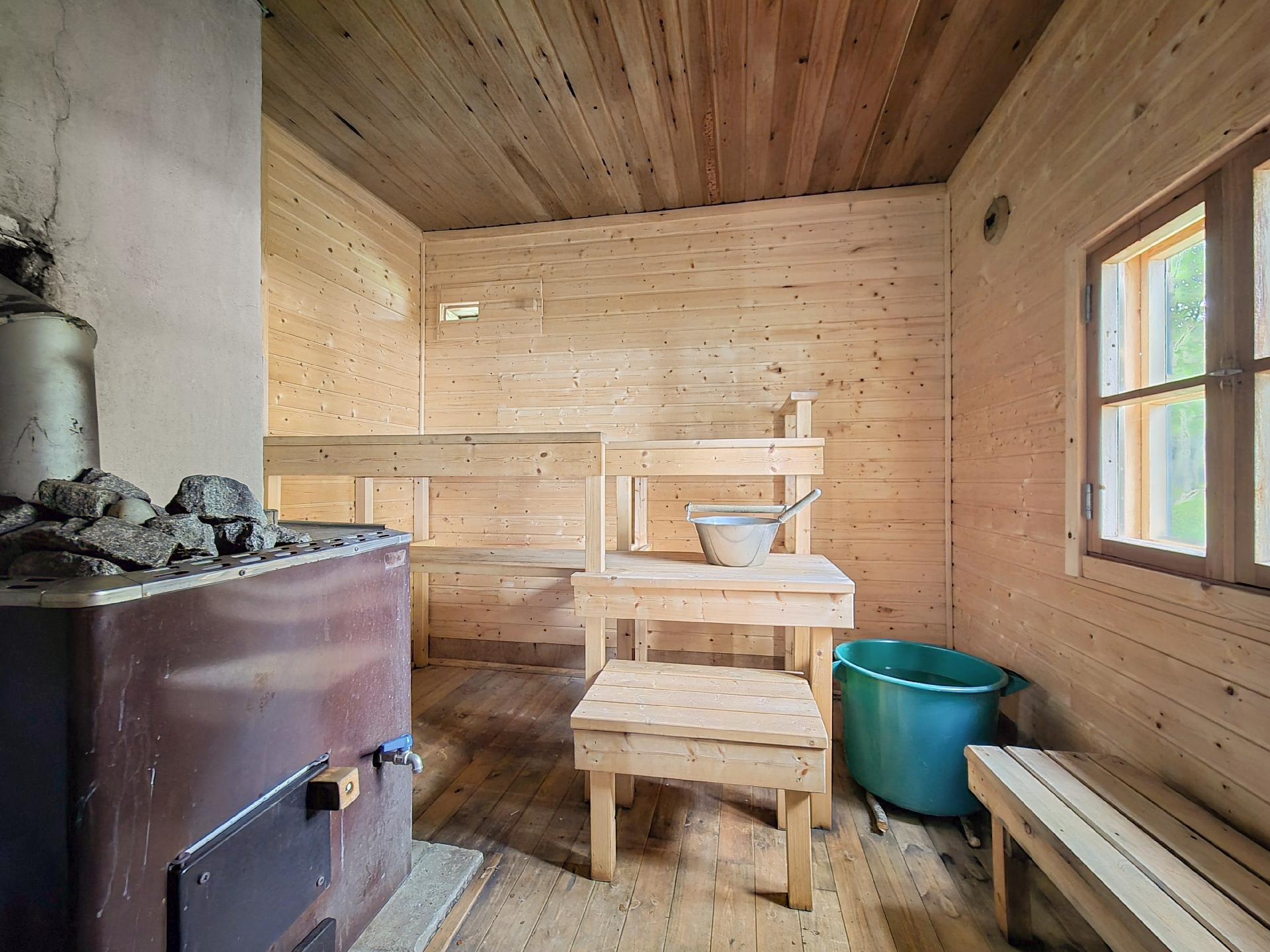 Puulämmitteinen sauna kantovedellä.