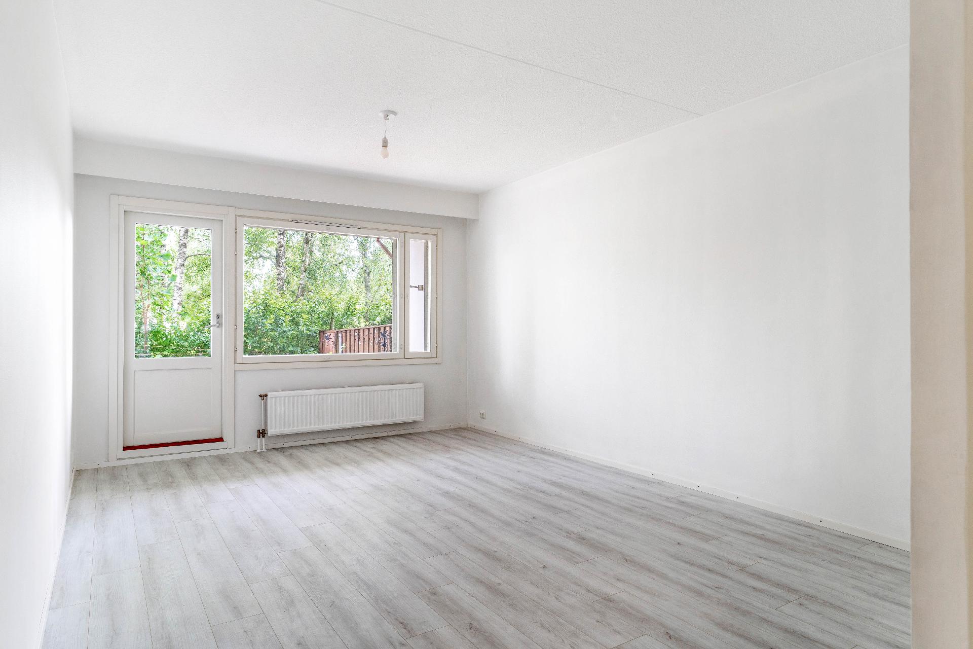 Valoisan avara olohuone josta käynti terassille