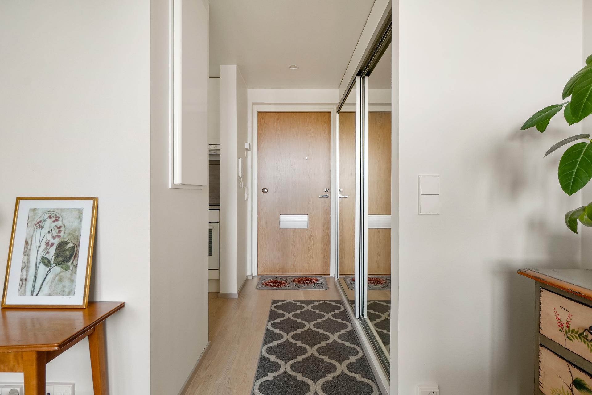 Näkymää kohti ulko-ovea, oikealle jäävät liukuovelliset vaatekaapistot.