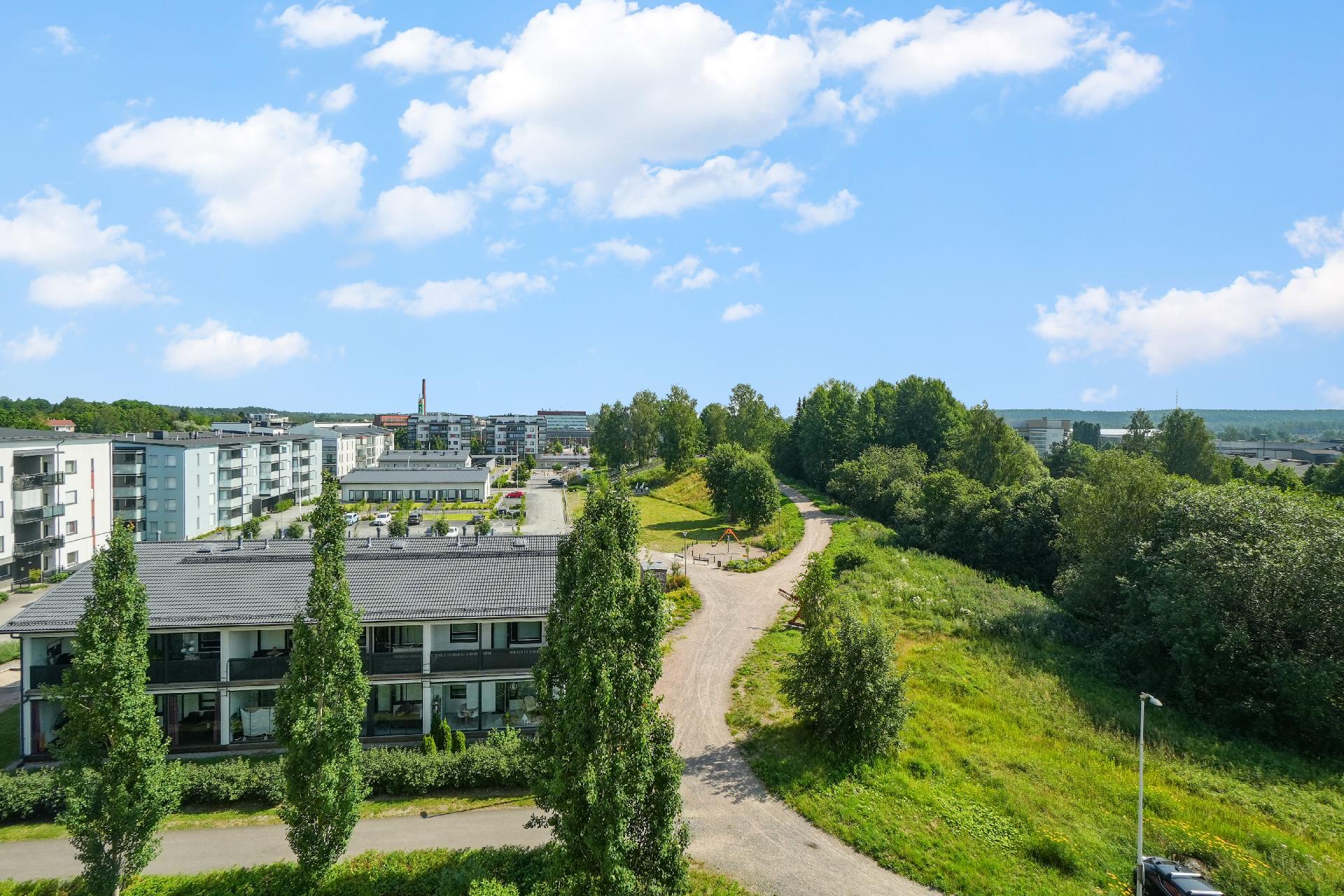 Parvekkeelta aukeaa näkymä kohti asuinaluetta ja puistoa.
