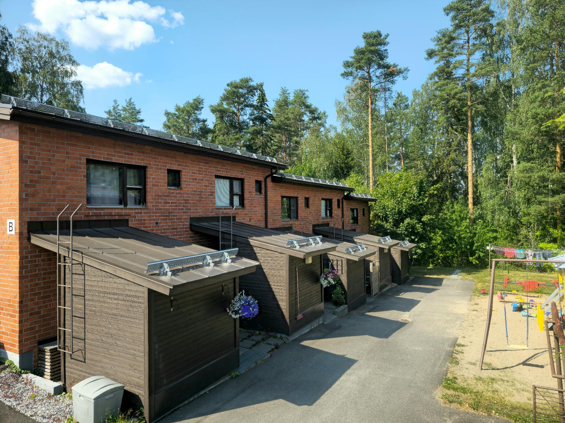 Taloyhtiö metsän laidassa.