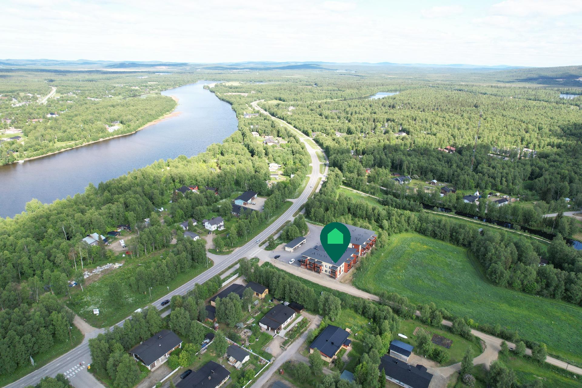 Rakennukset sijoittuvat rauhallisen pellon reunaan maalaismaisemiin