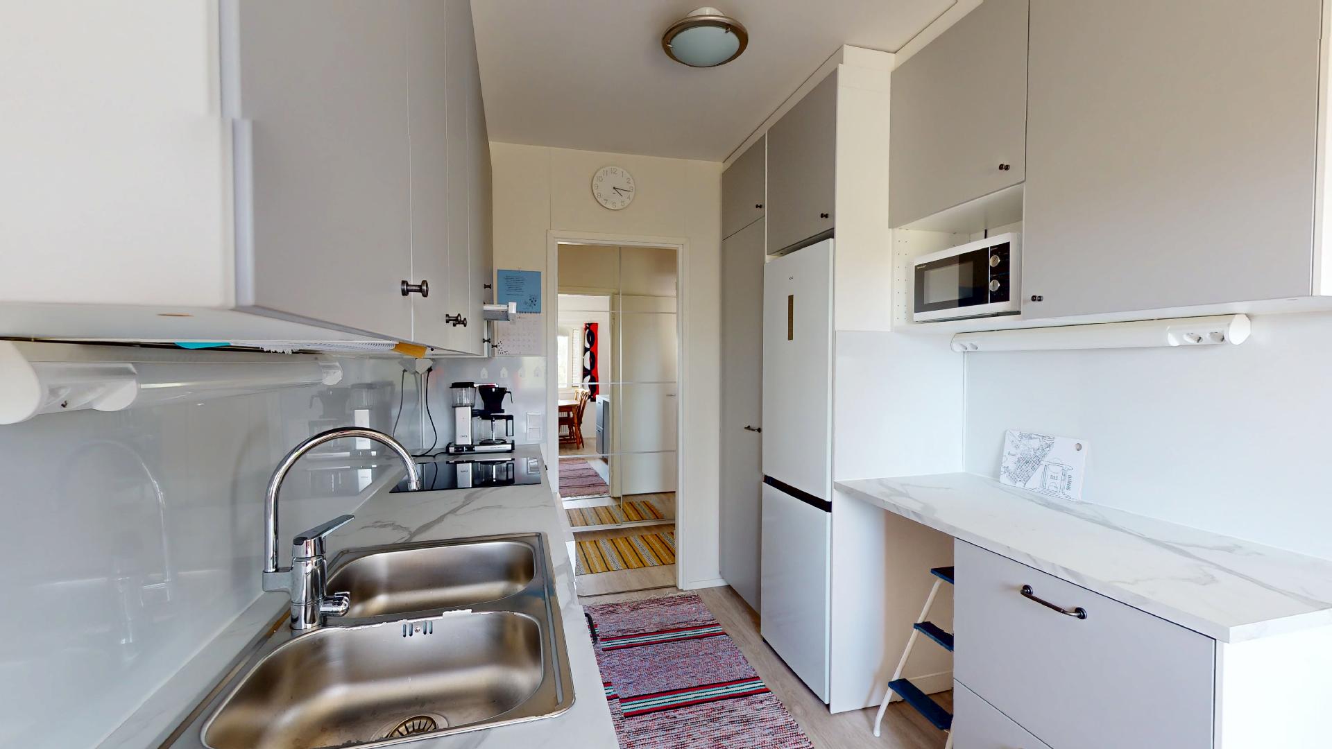 Keittiössä kauniit kaapistot ja teräsallas