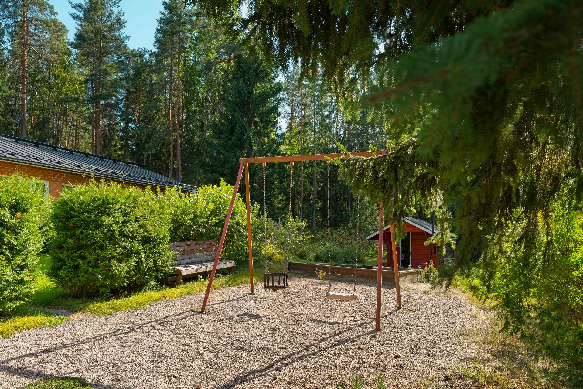 Pihakeinu ja lasten leikkipaikka on rauhaisan taloyhtiön suojissa.