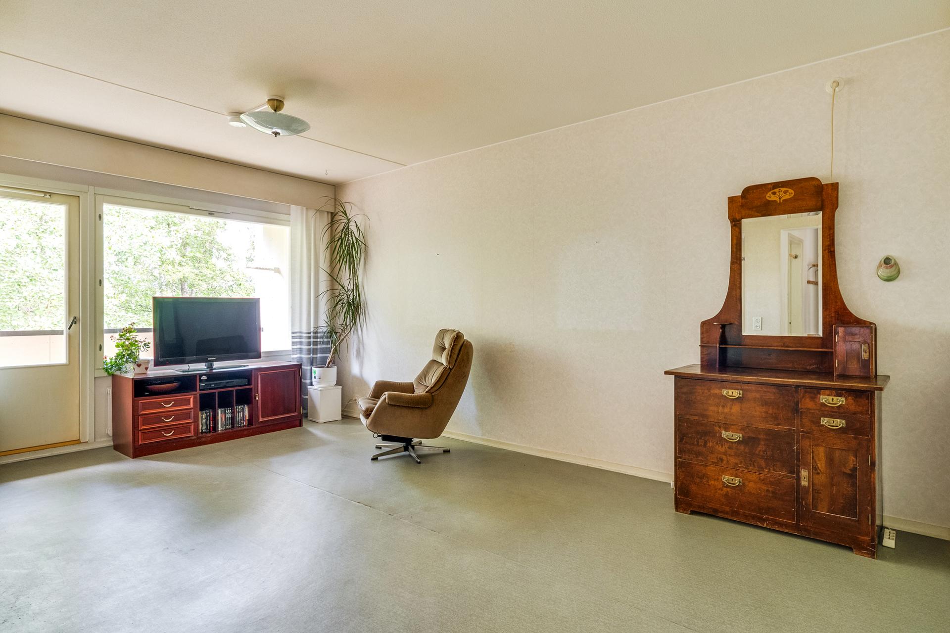 Tilava olohuone, josta on käynti parvekkeelle