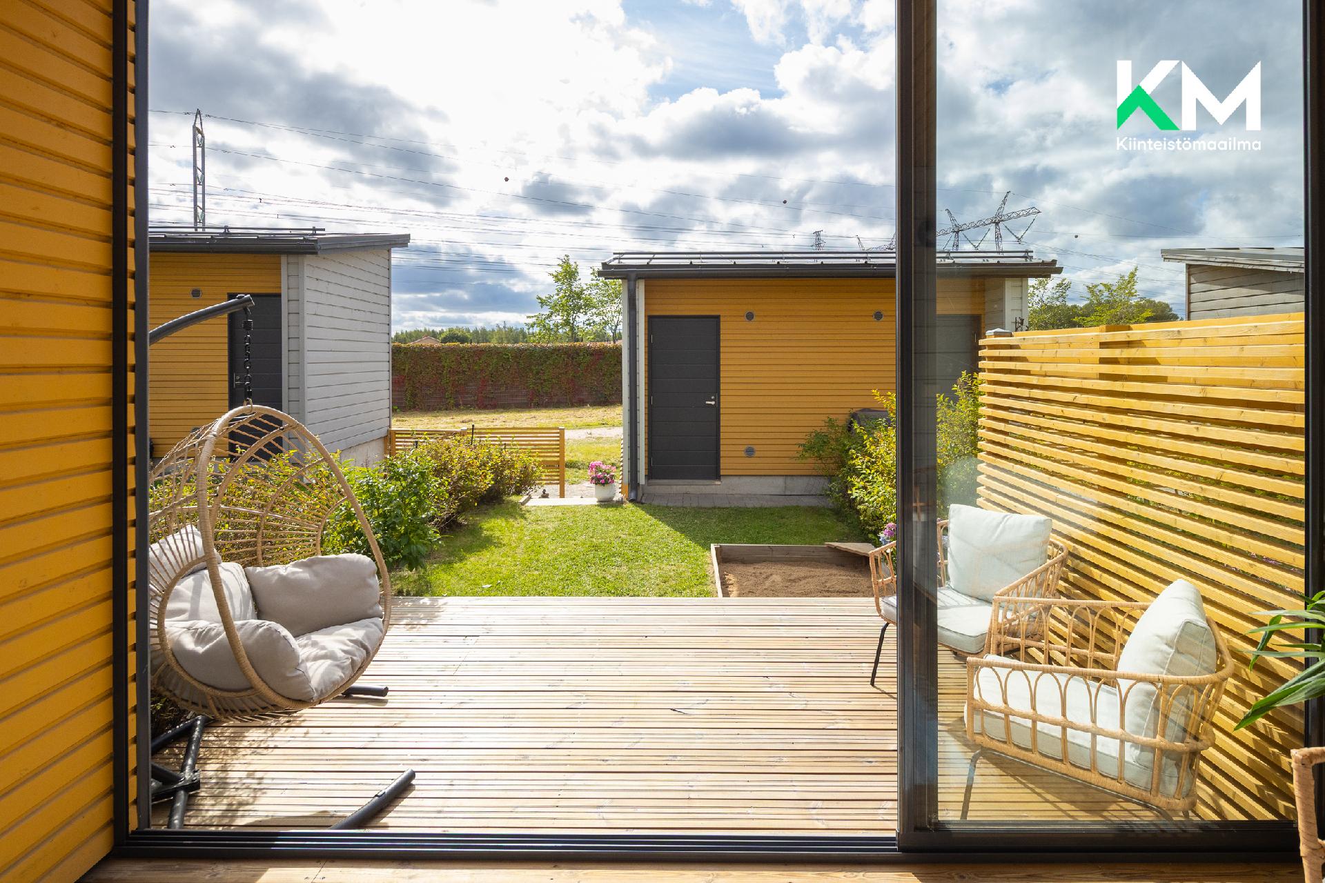 Takapiha ja lasitettu terassi kesällä