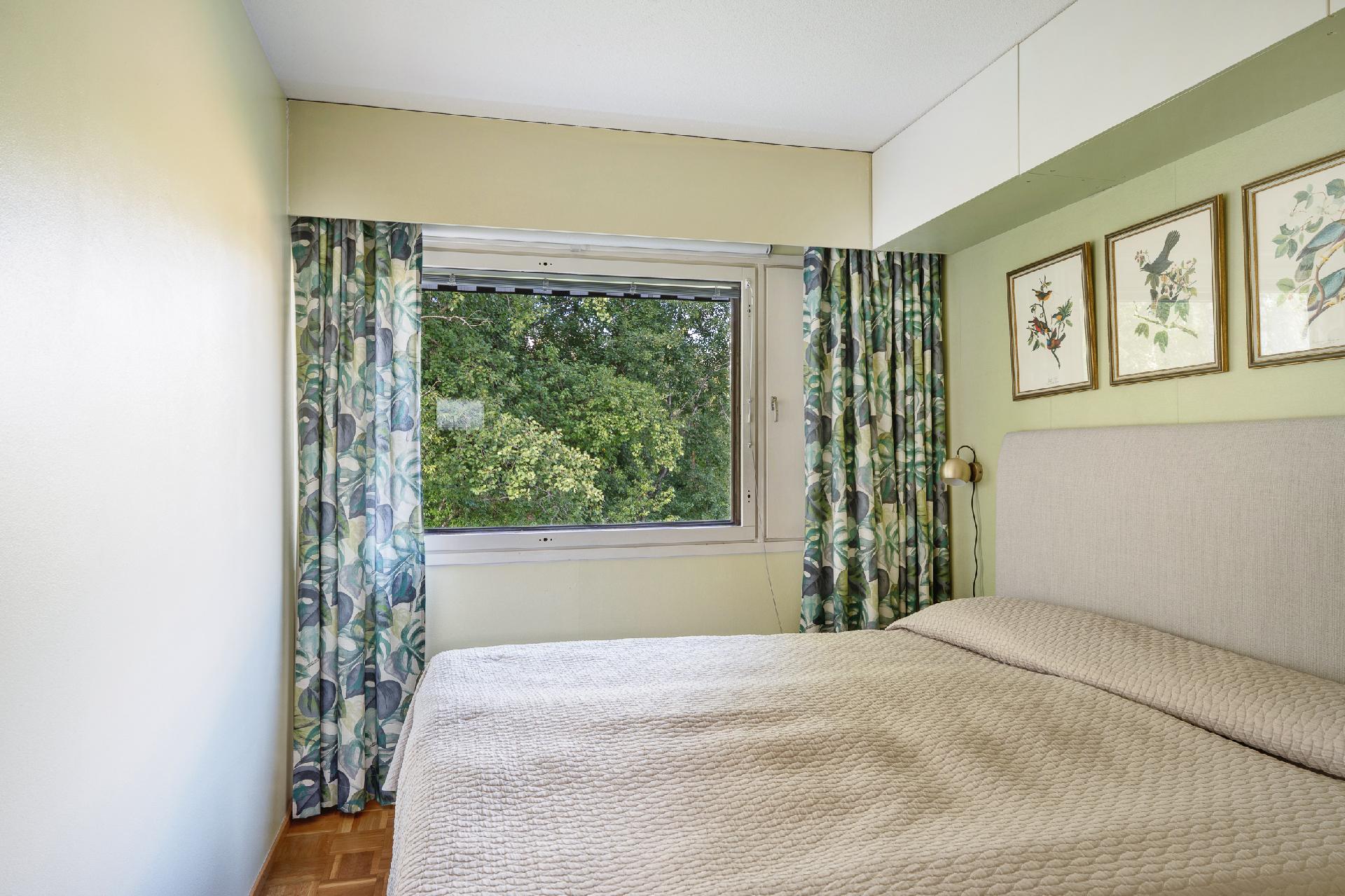 Isompi makuuhuone, josta maisema avautuu puron ja asunnon pihan puolelle