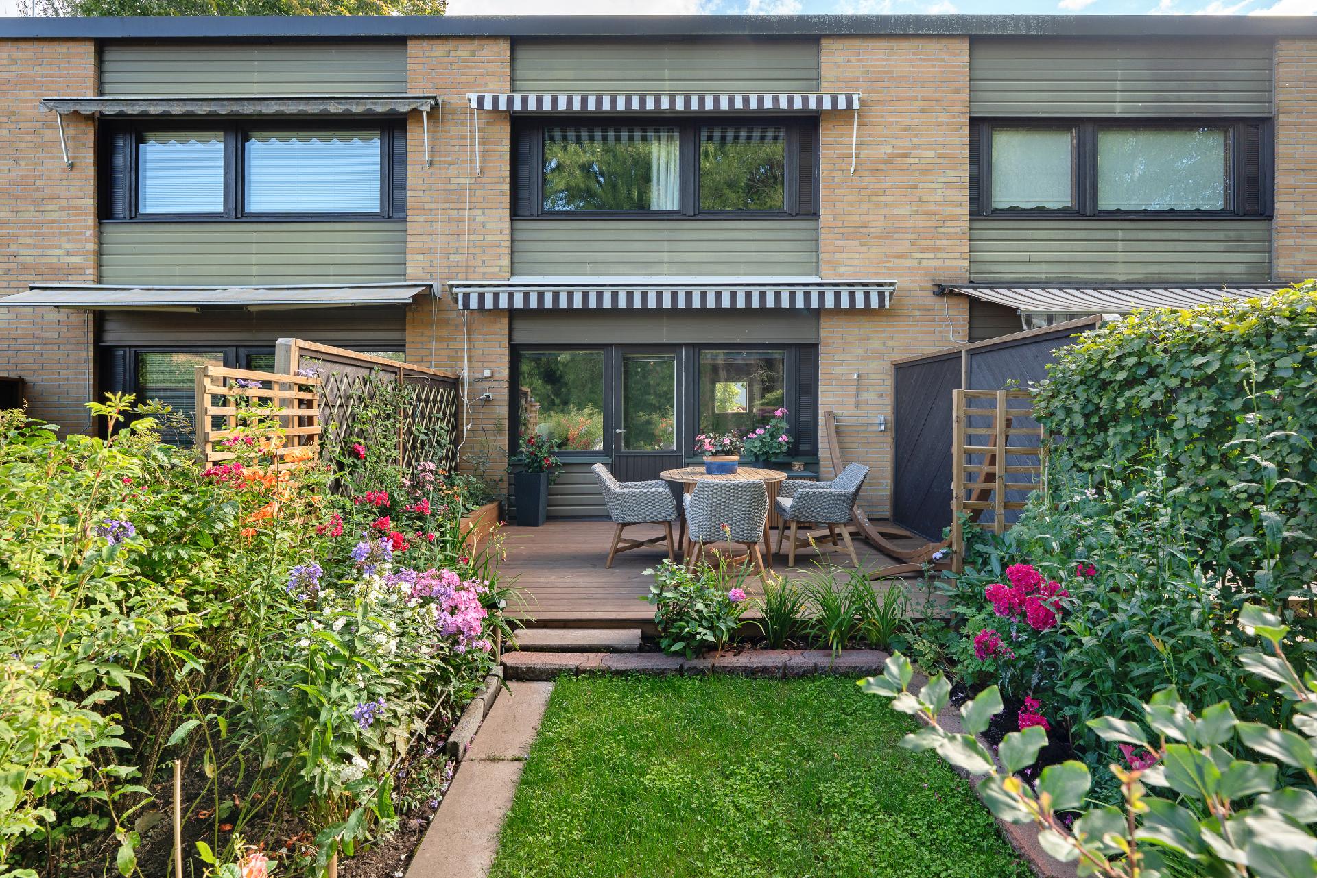 Asunnon kaunis piha katsottuna pihan perältä asuntoa kohti