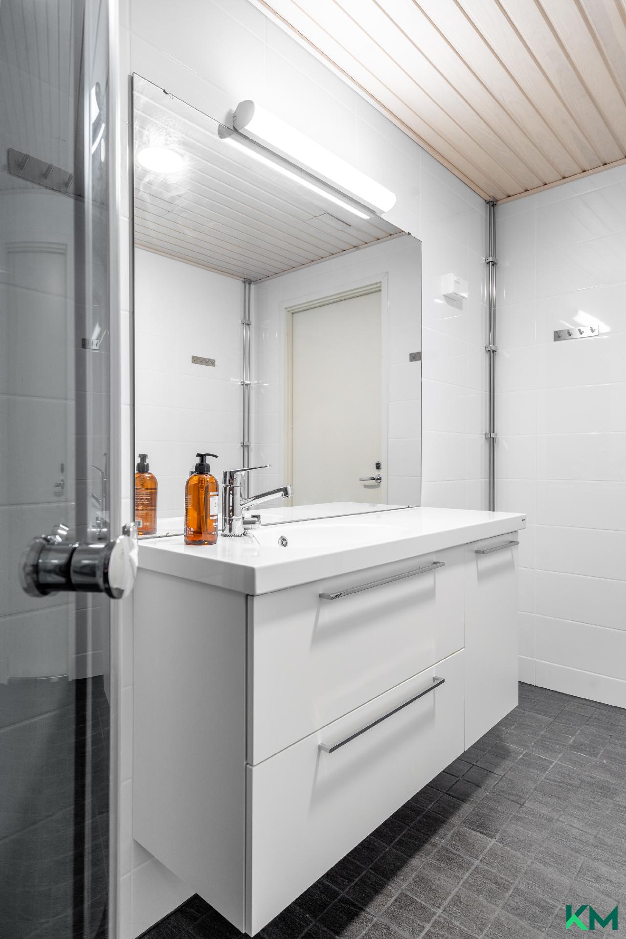 Kylpyhuoneen iso allaskaappi tarjoaa paljon säilytystilaa - Badrumsskåpet erbjuder gott om förvaringsutrymme.  