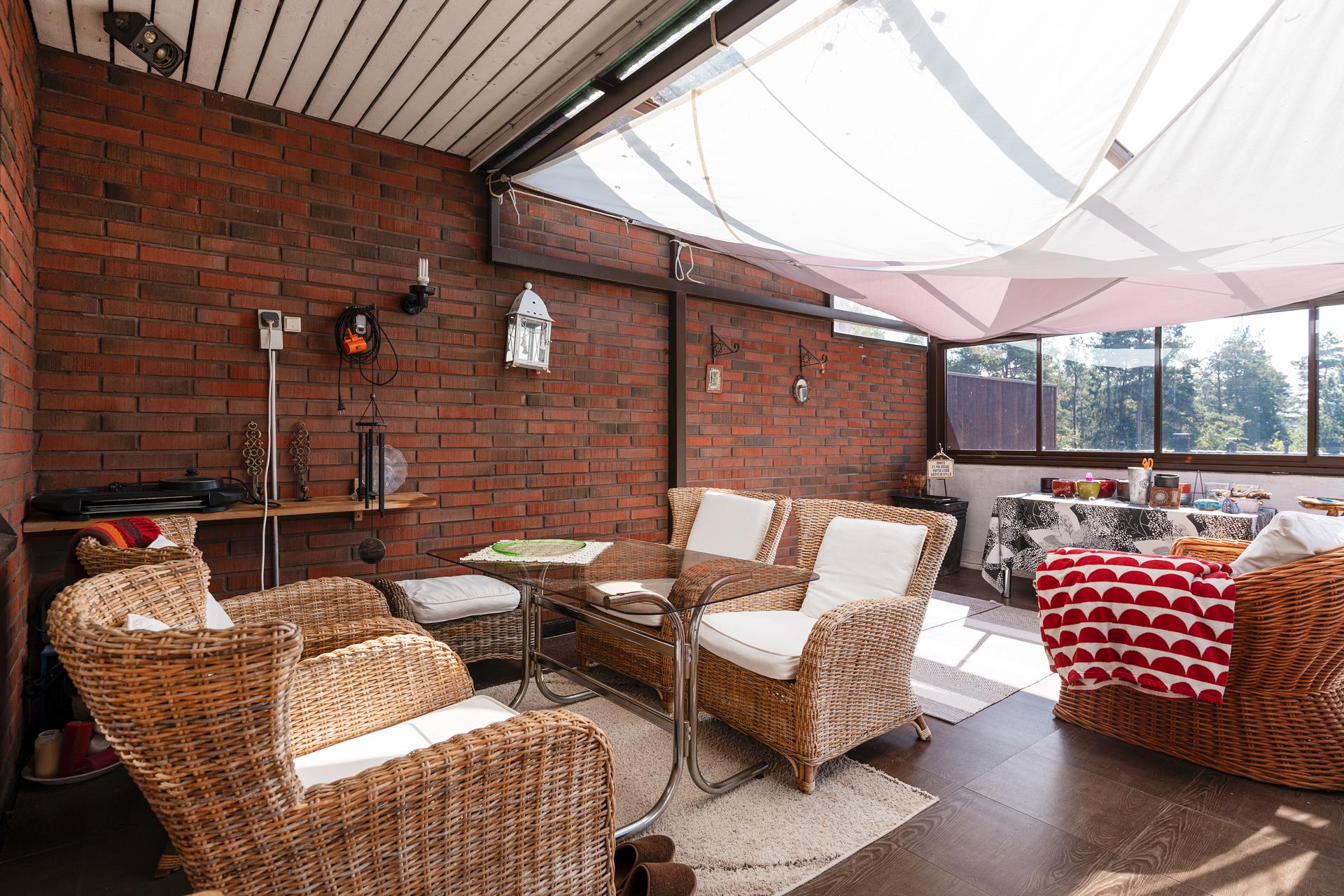 Lasitetulla parvekkeella on lasikate, kankaat suojaavat auringolta