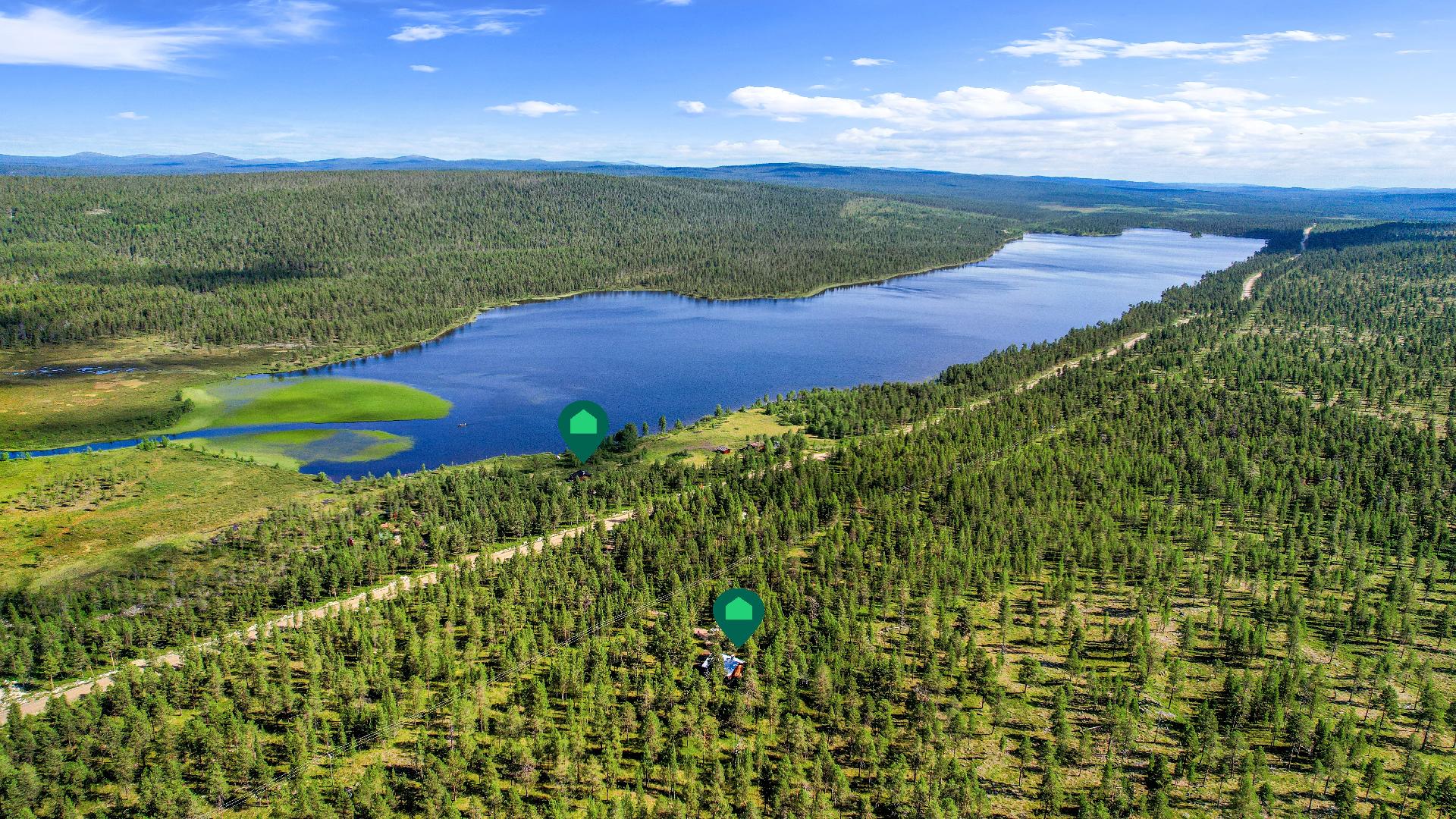 Kaksi mökkiä, toinen Pyhäjärven rannassa ja toinen Angelintien toisella puolella.