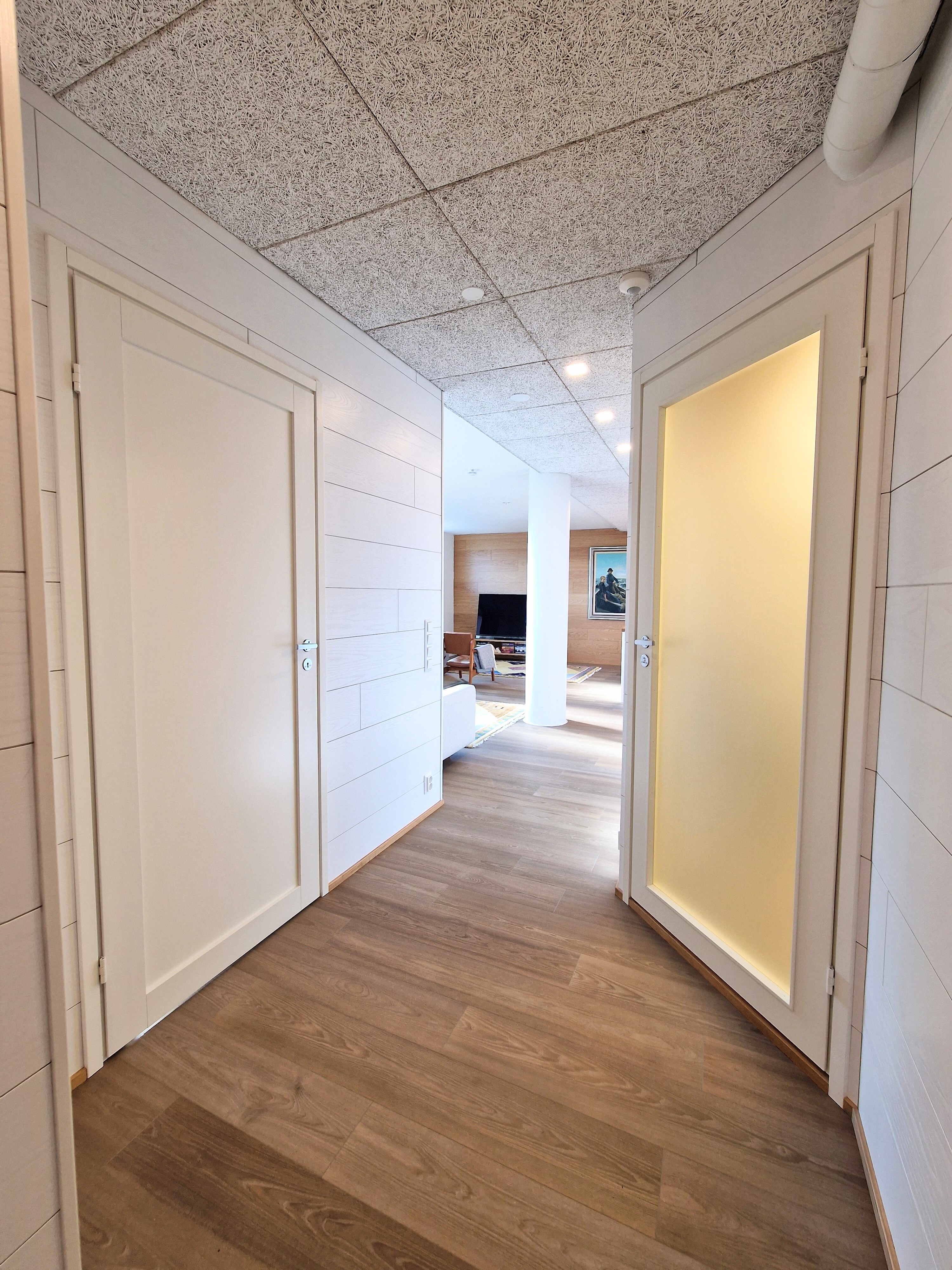 Kylpyhuoneen ovessa maitolasi, vastapäätä pieni makuuhuone