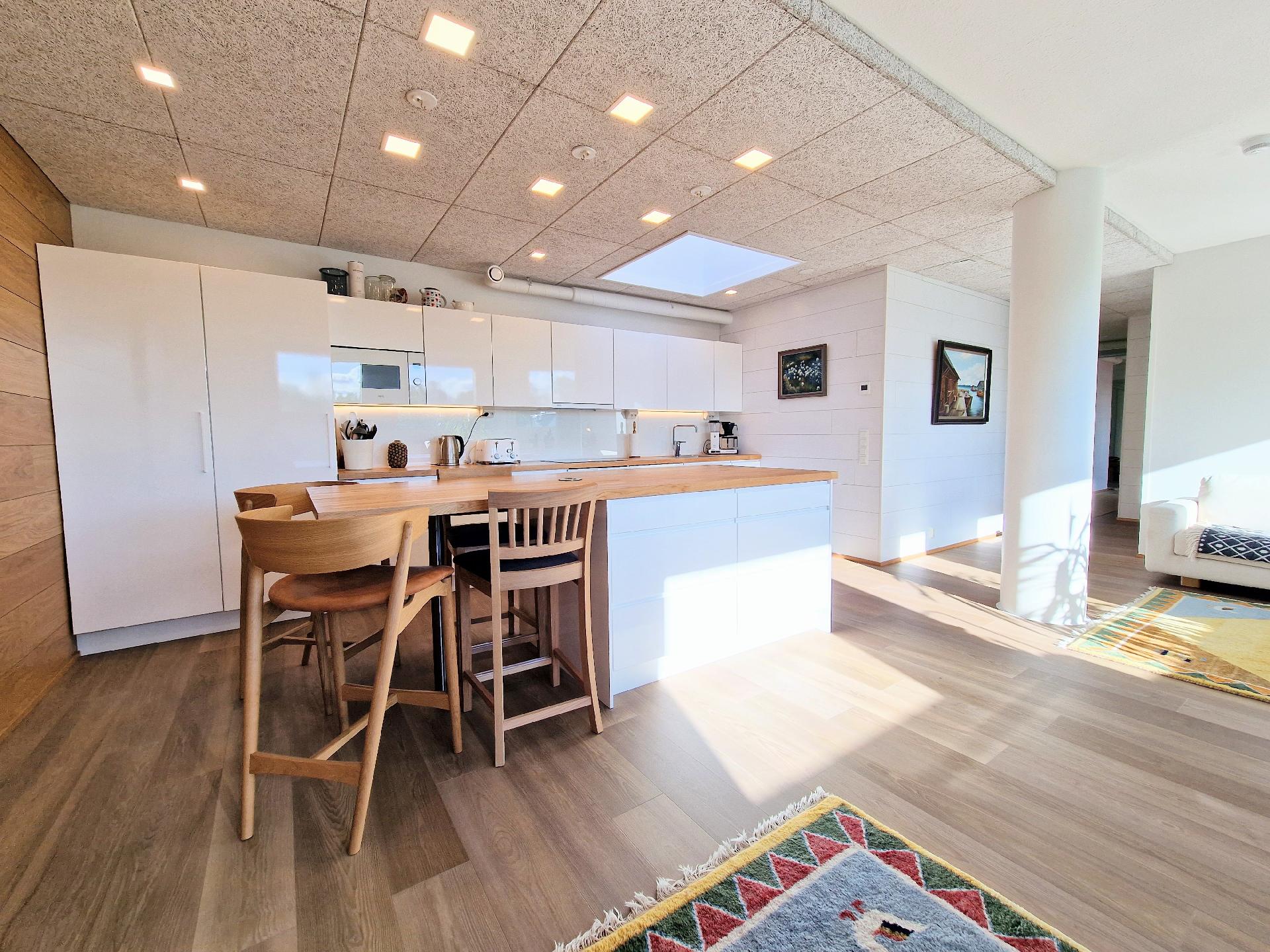 Korkeakiiltoiset valkoiset kalusteet tuovat tilantuntua