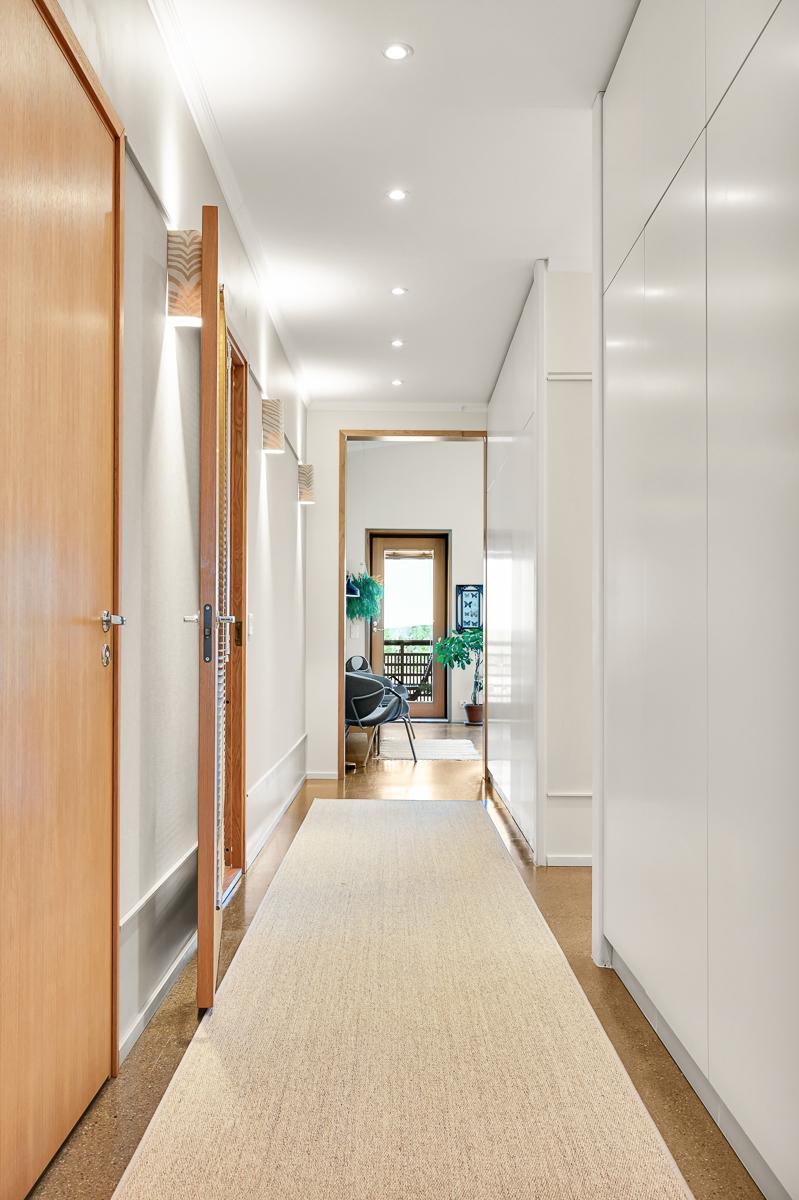 Käytävän varrella keittiön ja olohuoneen välissä runsaasti kaappitilaa